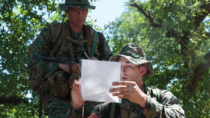 Petty Officer 2nd Class Thomas O. Dugan (left), a hospital corpsman with Headquarters and Service Company, 6th Engineer Support Battalion, 4th Marine Logistics Group, Marine Forces Reserve, and Petty Officer 2nd Class Adam C. Wild (right), a hospital corpsman and instructor for the Basic Medical Technician Corpsman Program, Medical Education and Training Campus, check a map at a land navigation exercise during a Fleet Marine Force reconnaissance corpsman screening in San Antonio, April 21, 2016.