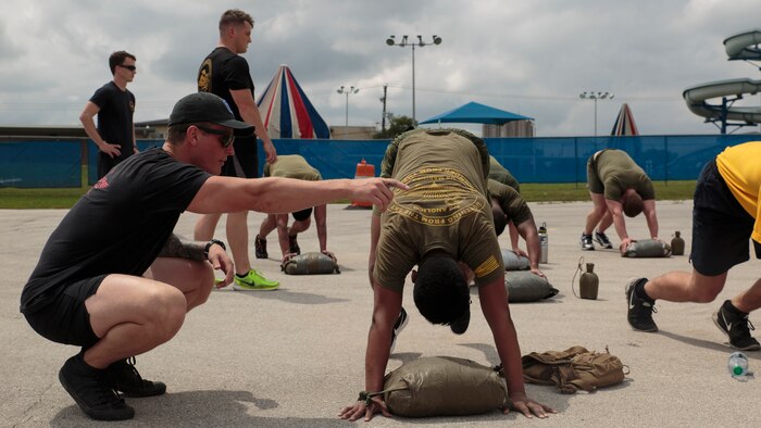 Petty Officer 1st Class Matthew J. Cool, a Fleet Marine Force reconnaissance corpsman and Inspector-Instructor medical staff with 4th Force Reconnaissance Company, 4th Marine Division, Marine Forces Reserve, corrects Seaman Ivan Zuniga, a hospital corpsman with 3rd Air Naval Gunfire Liaison Company, Force Headquarters Group, Marine Forces Reserve, on his form at a physical training event during a FMF reconnaissance corpsman screening in San Antonio, April 19, 2016. The screening was hosted by 4th Reconnaissance Battalion, 4th Marine Division, Marine Forces Reserve, for Reserve Sailors to gain familiarity with the demands of the FMF reconnaissance corpsman pipeline. 