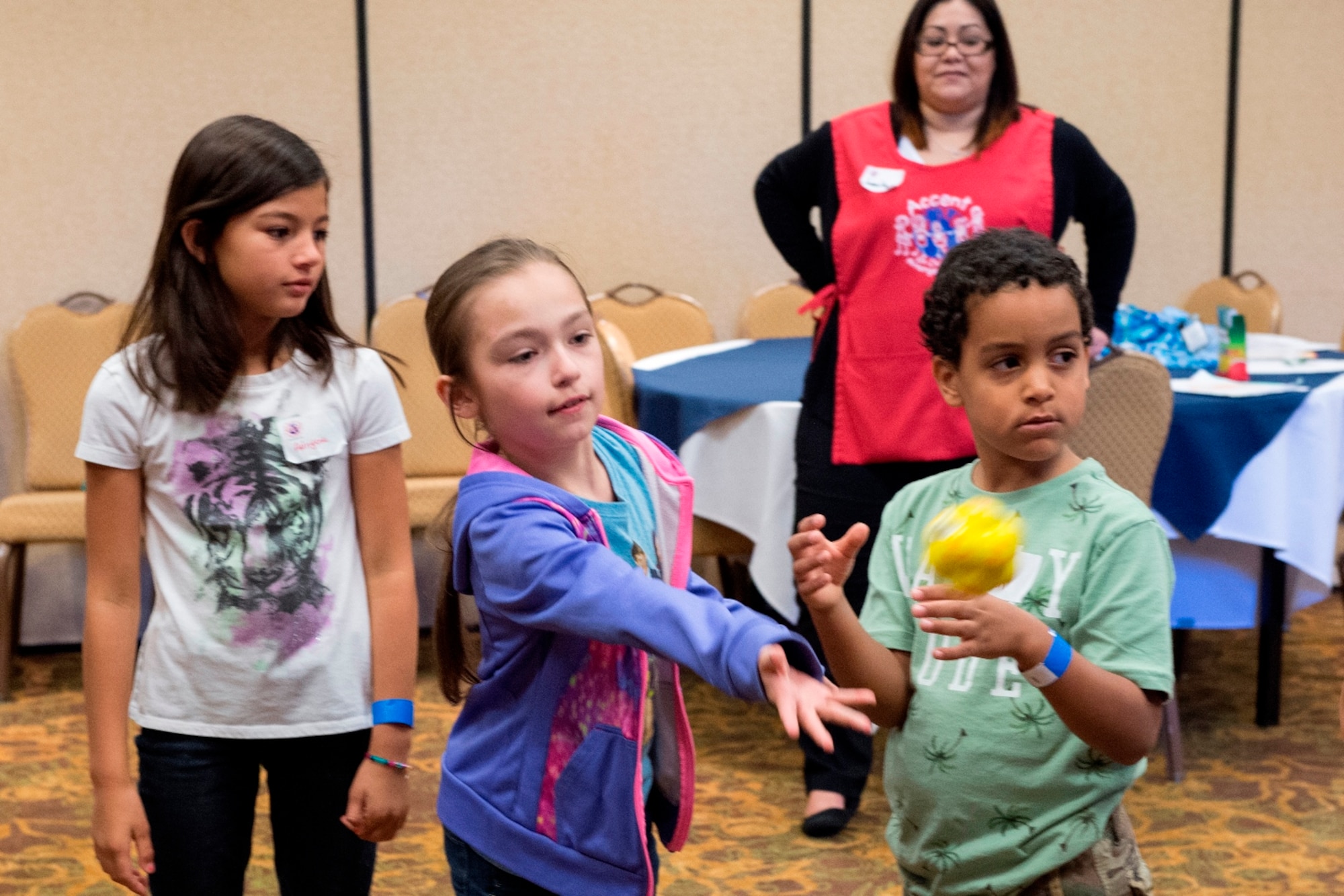 Alexis Badiano, daughter of Maj. Francisco Badiano from the 622nd Civil Engineer Flight at Dobbins Air Reserve Base, Georgia, tosses a ball April 23, 2016, to other children during a game used to teach communication skills at an Air Force Reserve Yellow Ribbon Reintegration Program event in Dallas. During the event children participate in a variety of activities developed to help them cope with the deployment of a military family member. (U.S. Air Force photo/Tech. Sgt. Benjamin Mota)