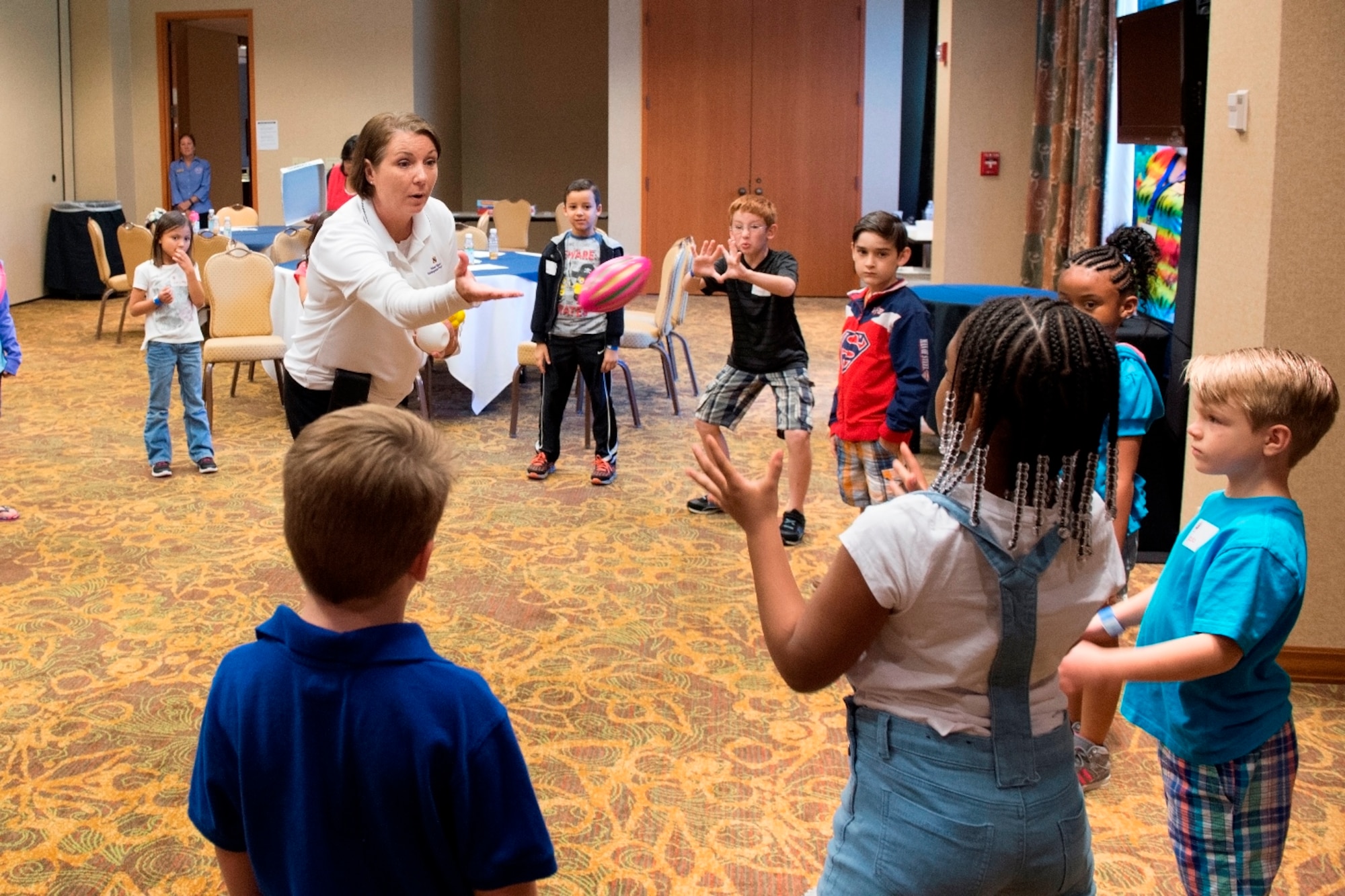 Senior Master Sgt. Jackie Zawada, a program manager with the Air Force Reserve Yellow Ribbon Reintegration Program, plays with children April 23, 2016, during a game used to teach communication skills at a Yellow Ribbon event in Dallas. During the event, children had an opportunity to tell their stories and share their feelings about their parent's recent deployments. (U.S. Air Force photo by Tech. Sgt. Benjamin Mota)
	 
