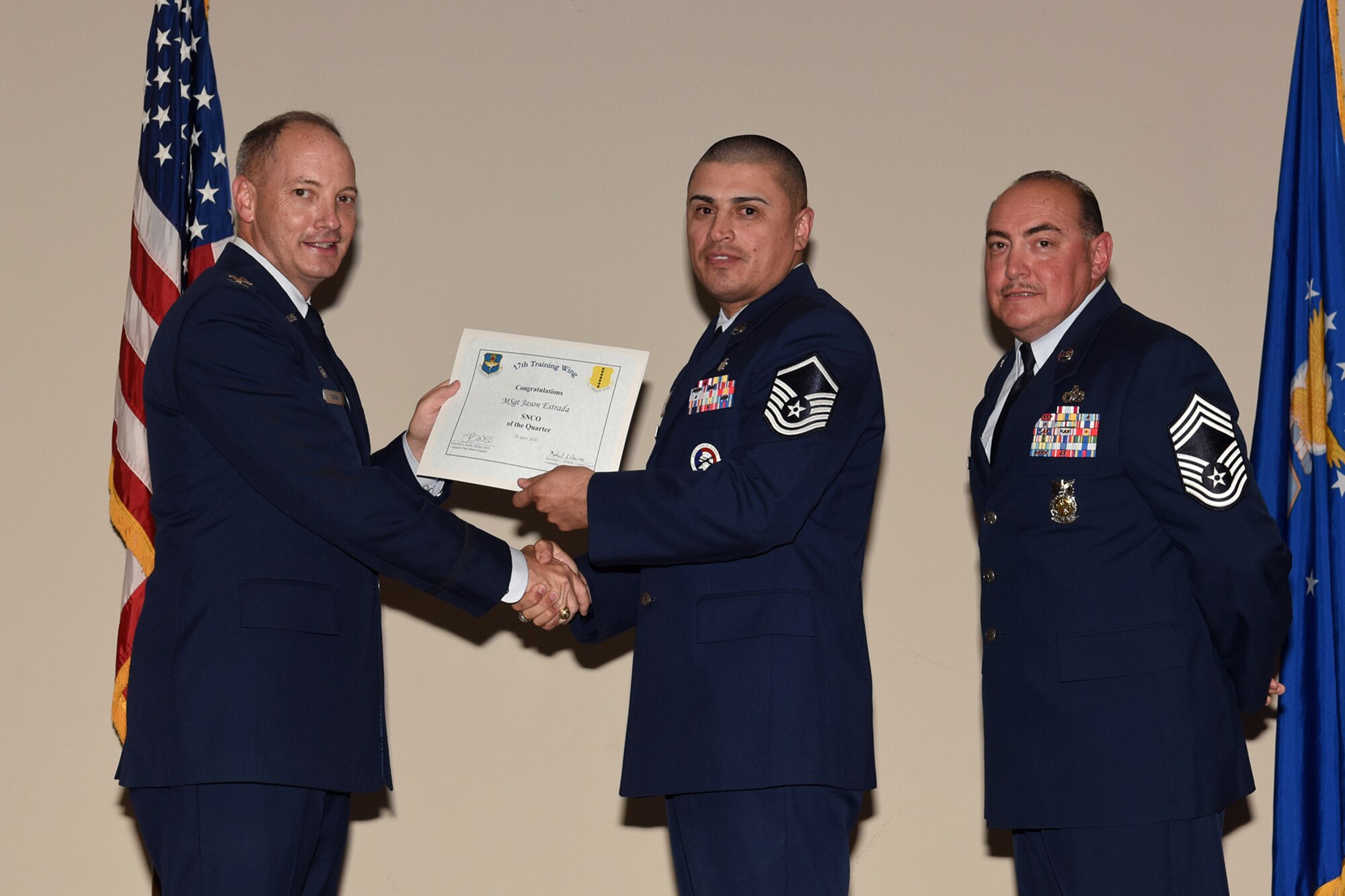 U.S. Air Force Col. Michael L. Downs, 17th Training Wing Commander, and Chief Master Sgt. Jesus Longoria Jr., 312th Training Squadron superintendent, present the 17th Training Wing Senior NCO of the Quarter award to Master Sgt. Jason Estrada, 17th Medical Support Squadron, during the wing quarterly awards ceremony at the Event Center on Goodfellow Air Force Base, Texas, April 29, 2016. (U.S. Air Force photo by Staff Sgt. Laura R. McFarlane/Released)