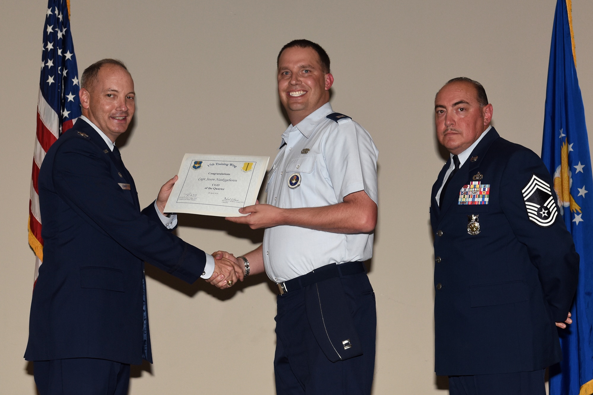 U.S. Air Force Col. Michael L. Downs, 17th Training Wing Commander, and Chief Master Sgt. Jesus Longoria Jr., 312th Training Squadron superintendent, present the Company Grade Officer of the Quarter award to Capt. Jason Naaktgeboren, 315th Training Squadron, during the wing quarterly awards ceremony at the Event Center on Goodfellow Air Force Base, Texas, April 29, 2016. (U.S. Air Force photo by Staff Sgt. Laura R. McFarlane/Released)