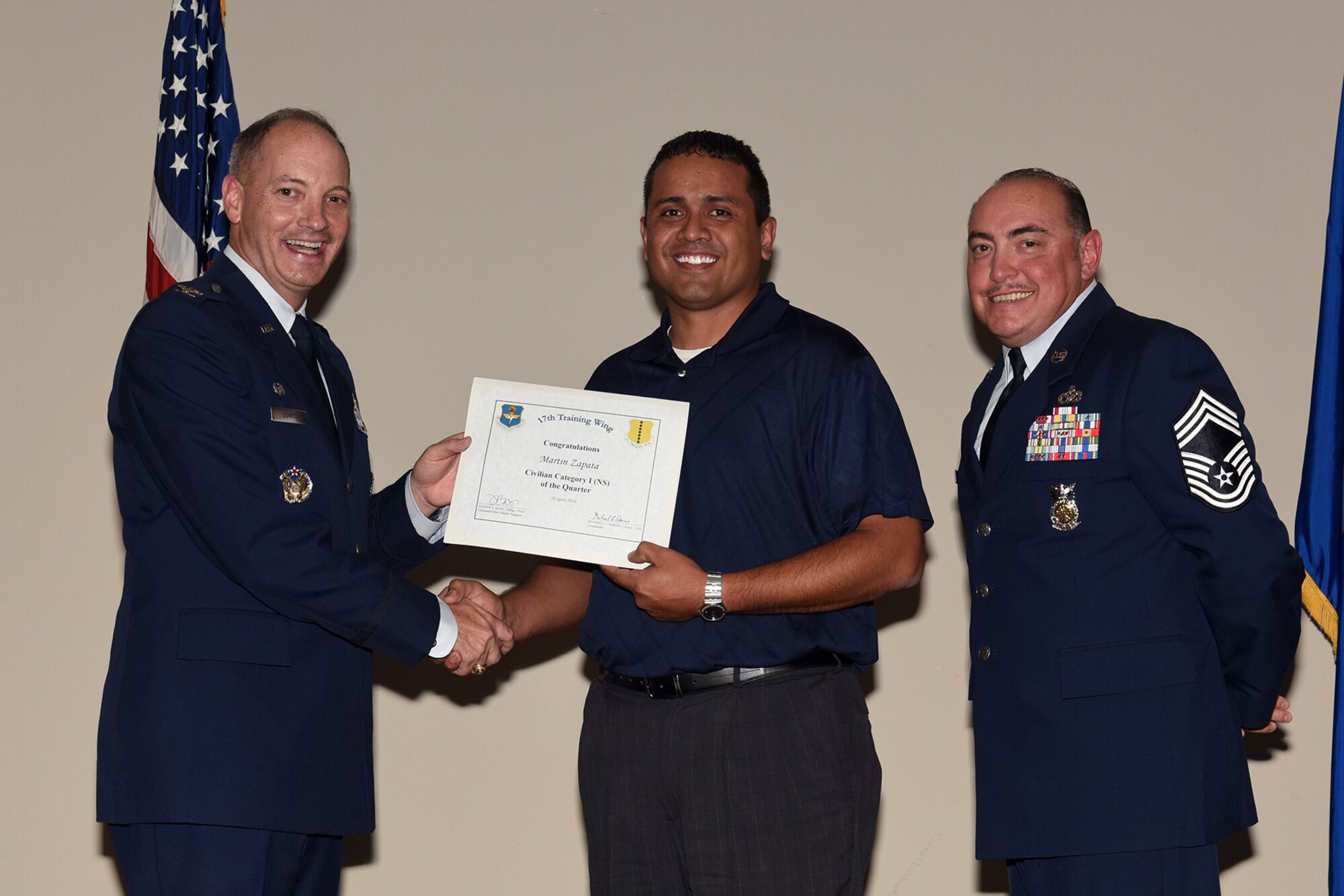 U.S. Air Force Col. Michael L. Downs, 17th Training Wing Commander, and Chief Master Sgt. Jesus Longoria Jr., 312th Training Squadron superintendent, present the 17th Training Wing Civilian Category I Non-Supervisory of the Quarter award to Martin Zapata, 17th Logistics Readiness Squadron, during the wing quarterly awards ceremony at the Event Center on Goodfellow Air Force Base, Texas, April 29, 2016. (U.S. Air Force photo by Staff Sgt. Laura R. McFarlane/Released)