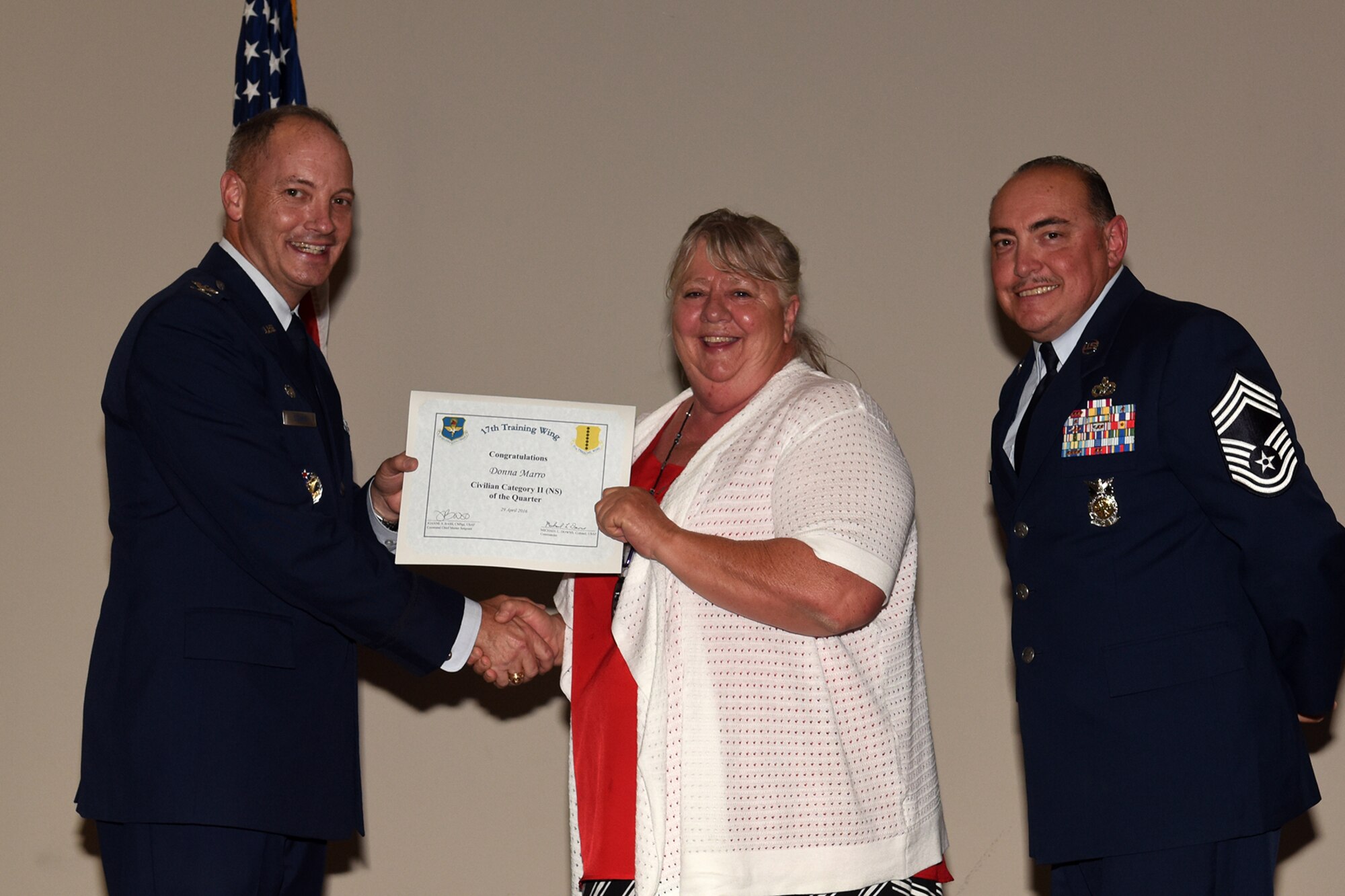U.S. Air Force Col. Michael L. Downs, 17th Training Wing Commander, and Chief Master Sgt. Jesus Longoria Jr., 312th Training Squadron superintendent, present the 17th Training Wing Civilian Category II Non-Supervisory of the Quarter award to Donna Marro, 17th Medical Group, during the wing quarterly awards ceremony at the Event Center on Goodfellow Air Force Base, Texas, April 29, 2016. (U.S. Air Force photo by Staff Sgt. Laura R. McFarlane/Released)