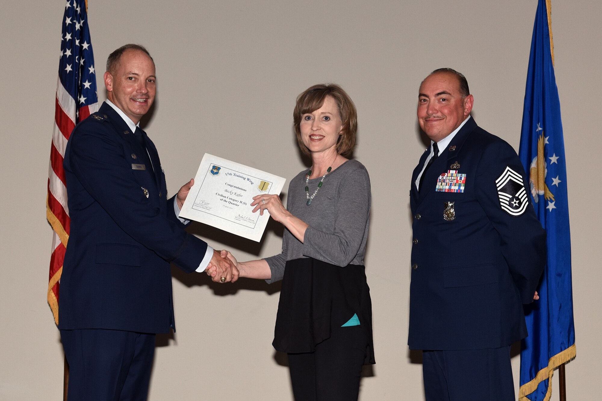 U.S. Air Force Col. Michael L. Downs, 17th Training Wing Commander, and Chief Master Sgt. Jesus Longoria Jr., 312th Training Squadron superintendent, present the 17th Training Wing Civilian Category II Supervisory of the Quarter award to Becky Kafer, 17th Training Support Squadron, during the wing quarterly awards ceremony at the Event Center on Goodfellow Air Force Base, Texas, April 29, 2016. (U.S. Air Force photo by Staff Sgt. Laura R. McFarlane/Released)