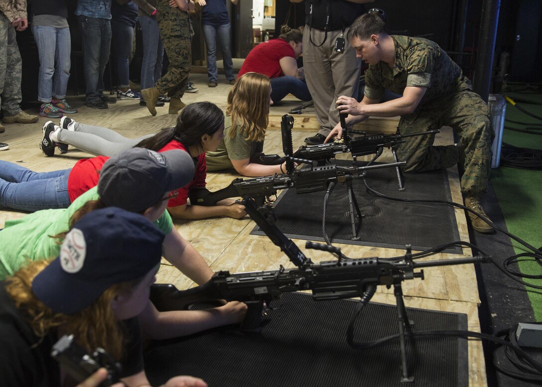 Spouses and family members of U.S. Marines learn how to properly load the M249 Squad Automatic Weapon during II Marine Headquarters Group’s: “In Their Boots Day” at Camp Lejeune, N.C., April 29, 2016. The spouses and family members spent a few hours at the Indoor Simulated Marksmanship Trainer getting the opportunity to safely operate the different weapons systems that the Marine Corps uses. (U.S. Marine Corps photo by Cpl. Justin T. Updegraff/ Released)