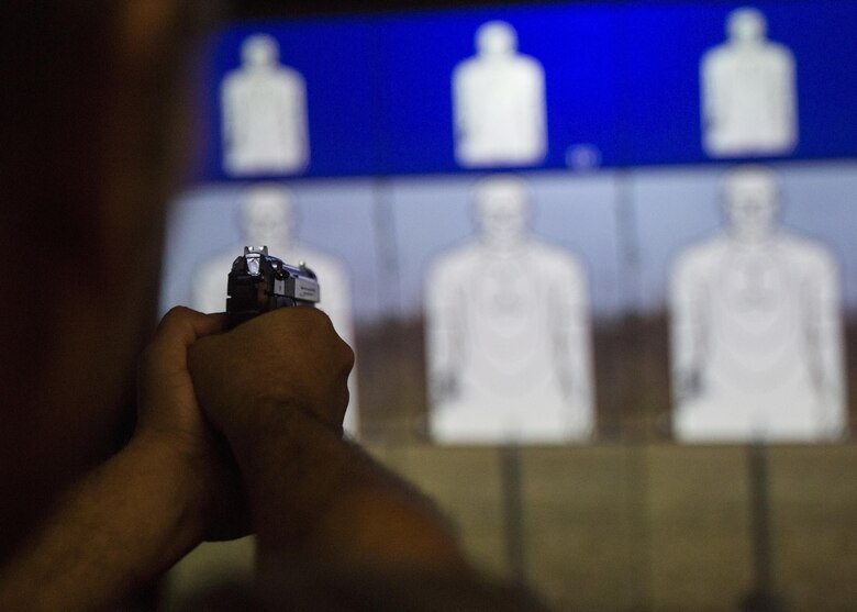 Retired Marine staff sergeant, Mario Canepa conducts a course of fire with an M9 Service Pistol during II Marine Headquarters Group’s: “In Their Boots Day” aboard Camp Lejeune, N.C., April 29, 2016. The spouses and family members spent a few hours at the Indoor Simulated Marksmanship Trainer getting the opportunity to safely operate the different weapons systems that the Marine Corps uses. (U.S. Marine Corps photo by Cpl. Justin T. Updegraff/ Released)