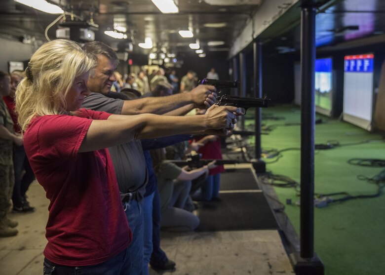 Family members and spouses shoot the M9 Service Pistol during II Marine Headquarters Group’s: “In Their Boots Day” aboard Camp Lejeune, N.C., April 29, 2016. The spouses and family members spent a few hours at the Indoor Simulated Marksmanship Trainer getting the opportunity to safely operate the different weapons systems that the Marine Corps uses. (U.S. Marine Corps photo by Cpl. Justin T. Updegraff/ Released)