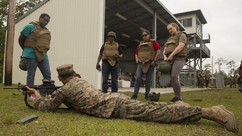Cpl. Seth Strong, a special communication signal collection analyst with 2nd Radio Bn, II Marine Headquarters Group goes over the course of fire with the spouses and family members during II MHG’s: “In Their Boots Day” aboard Camp Lejeune, N.C., April 29, 2016. During the course of fire, they shot in the standing, kneeling and prone position and received any needed corrections from the Marine assigned to them. (U.S. Marine Corps photo by Cpl. Justin T. Updegraff/ Released)