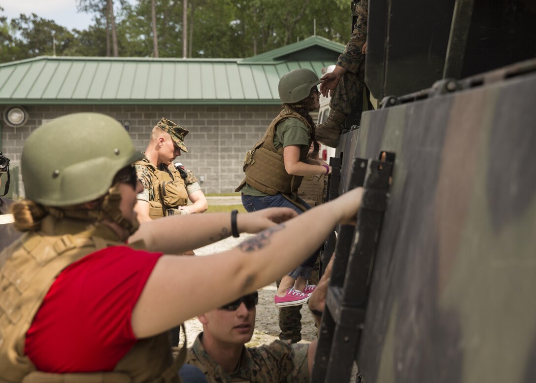Spouses and family members climb into the back of 7 tons and go on a short tour of the training area during II Marine Headquarters Group’s: “In Their Boots Day” aboard Camp Lejeune, N.C., April 29, 2016. From eating Meals Ready to Eat to conducting a live fire range, family members and spouses experienced what the Marine Corps is all about. (U.S. Marine Corps photo by Cpl. Justin T. Updegraff/ Released)