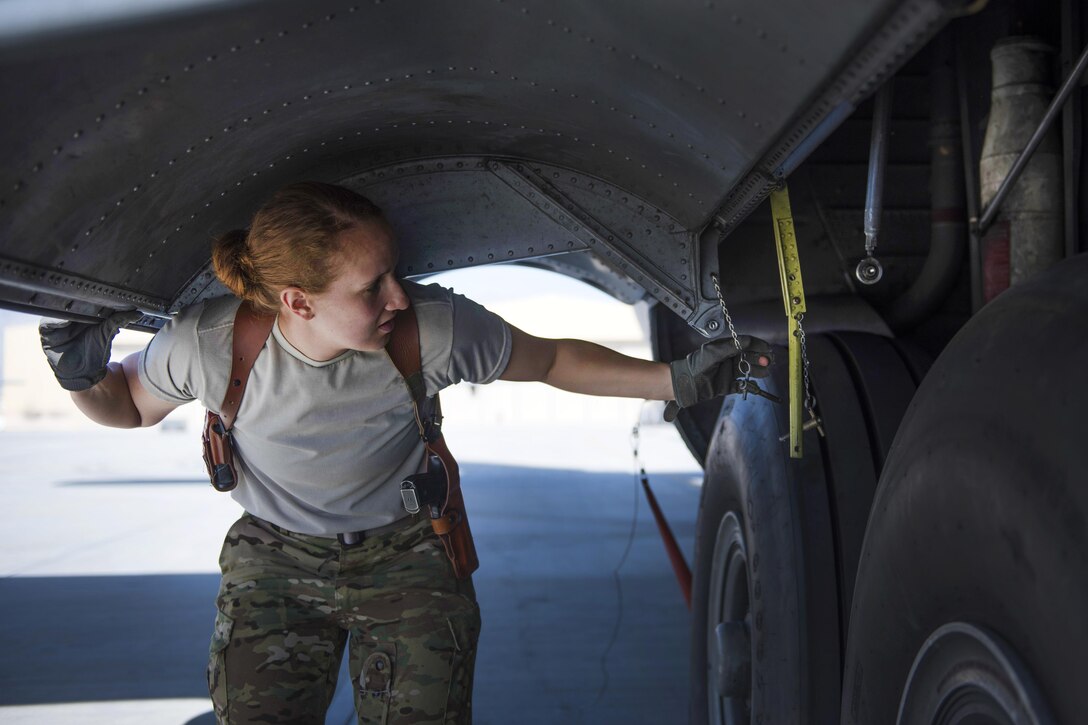 Air Force Senior Airman Jessica Jones lifts up the landing gear cover during a preflight inspection of a C-130J Super Hercules at Bagram Airfield, Afghanistan, April 29, 2016. Jones is a loadmaster assigned to the 774th Expeditionary Airlift Squadron. Air Force photo by Senior Airman Justyn M. Freeman
