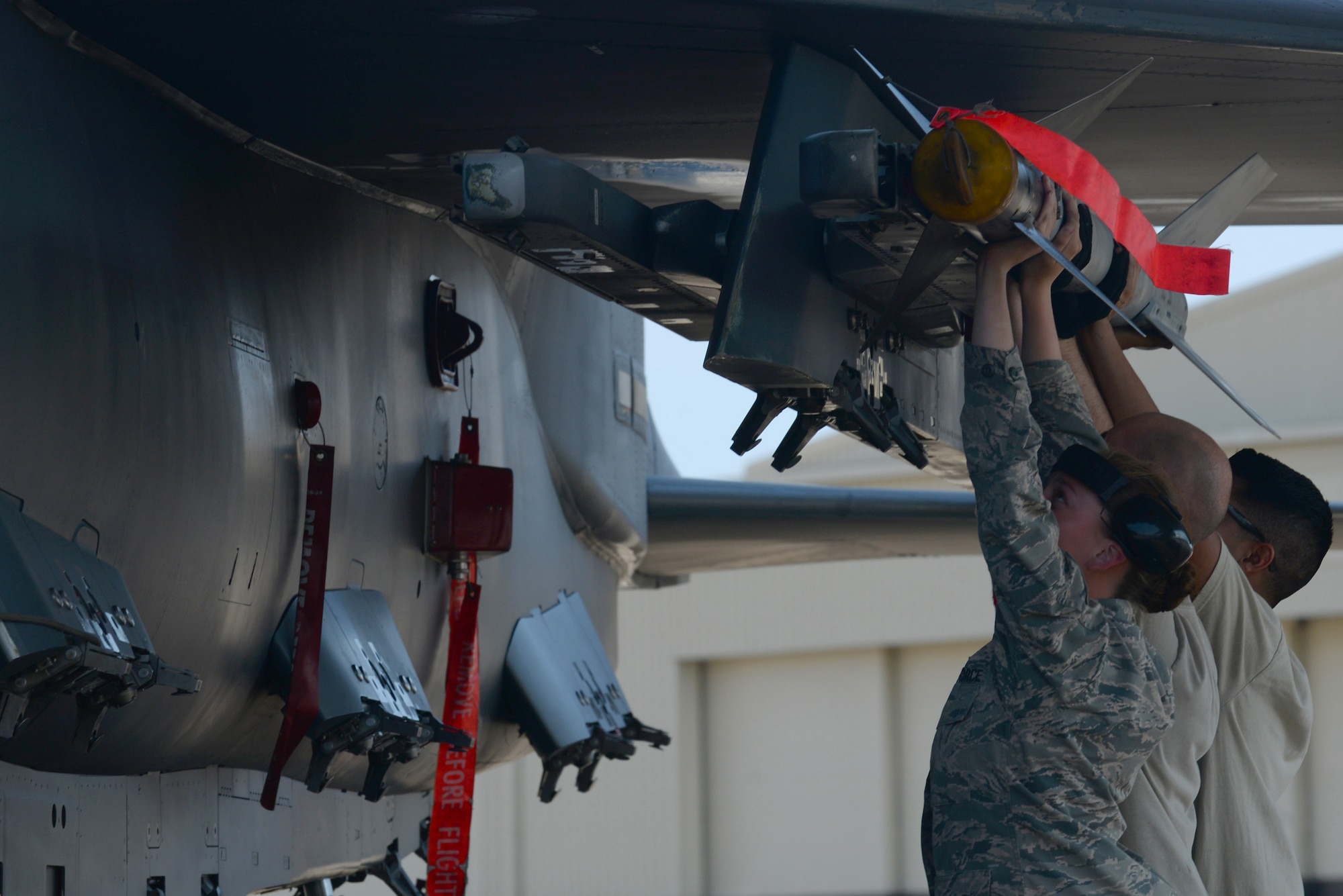 (Right to left) Airman 1st Class Bailey O’Dell, Staff Sgt. Nathaniel Bodell and Airman 1st Class Christian Garibay, 4th Aircraft Maintenance Squadron weapons load crew members, arm an F-15E Strike Eagle with an Aim 9 Sidewinder missile, April 27, 2016, at Seymour Johnson Air Force Base, North Carolina. F-15Es were loaded with missiles and bombs before flying to Hill Air Force Base, Utah, to participate in exercise Combat Hammer. (U.S. Air Force photo by Airman 1st Class Ashley Williamson/Released)