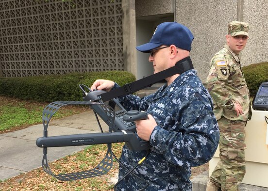Information Systems Technician 1st Class Michael Phillips, a staff member at Center for Information Dominance (CID) Keesler Air Force Base, practices with the Rohde & Schwarz Portable Receiver 100 (PR100), under Sgt. 1st Class Timothy Kowalski's guidance. The PR100 is a state-of-the-art tool used by spectrum managers worldwide to find sources of interference and is replacing an older model spectrum analyzer taught in CID Keesler's Spectrum Operations Apprenticeship Course. (U.S. Air Force photo by Tech. Sgt. Jason Stover, 333rd Training Squadron)