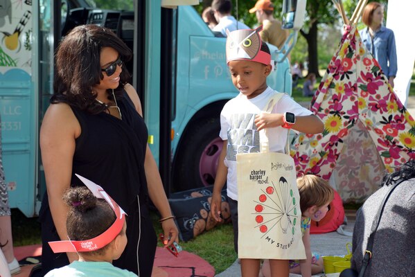 A mother helps a young environmentalist during an Earth Day festival celebration in Centennial Park.    