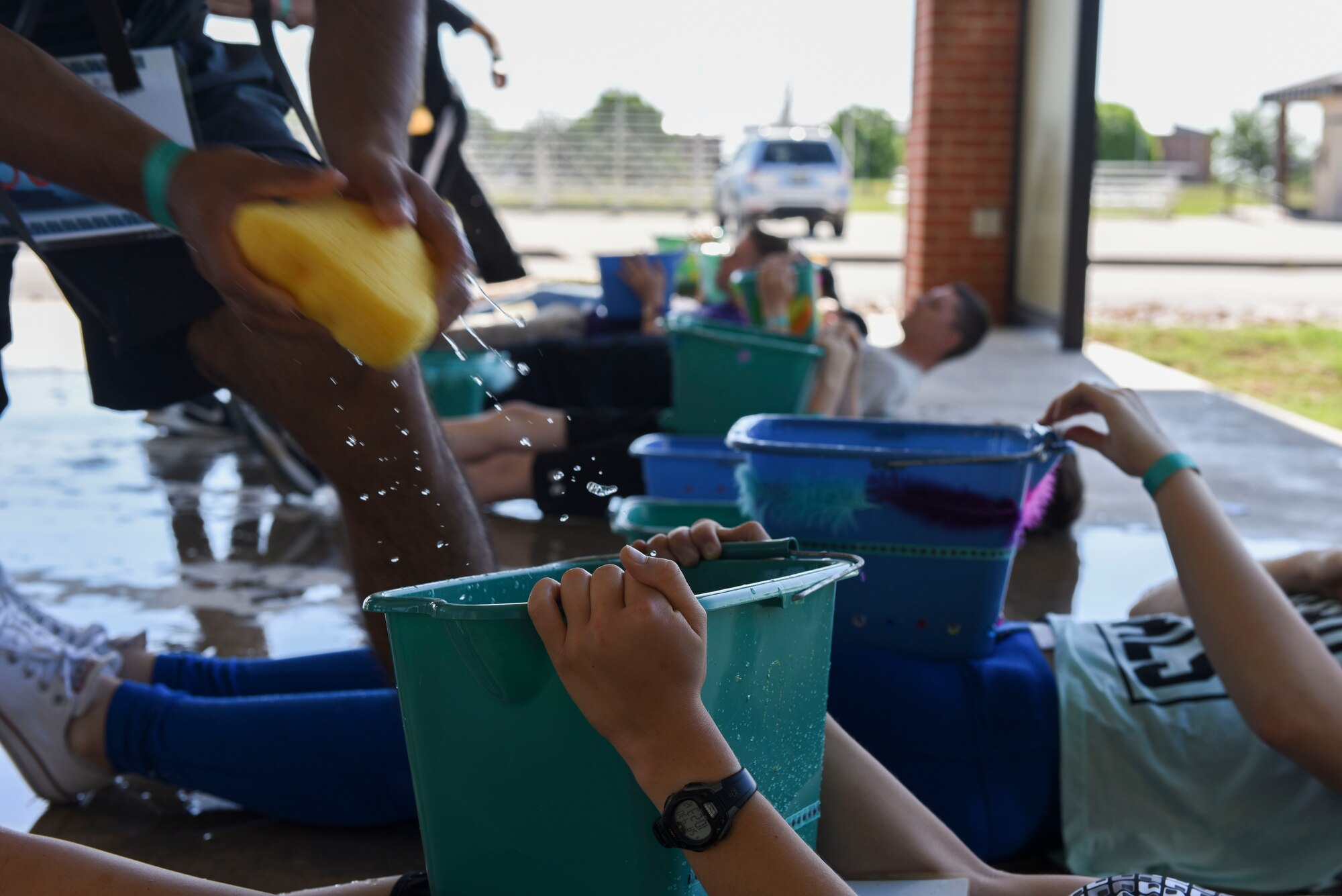 Participants of the sixth annual Sexual Assault Response Coordinator Challenge fill empty buckets with water using sponges at the Parade Field on Goodfellow Air Force Base, Texas, April 30, 2016. The Sexual Assault Prevention and Response staff educated contenders by asking them questions about SAPR. (U.S. Air Force photo by Airman 1st Class Chase Sousa/Released)