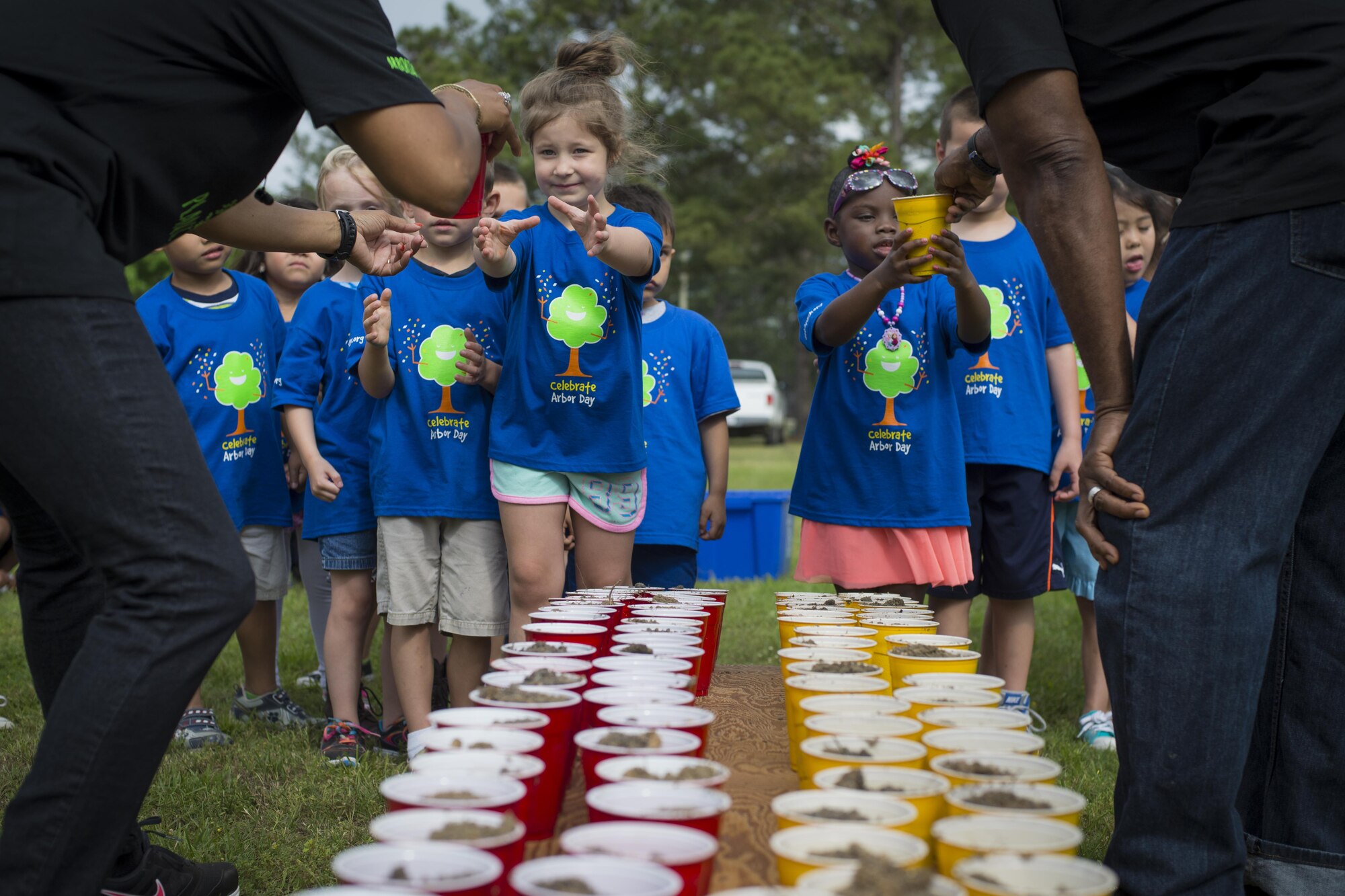 Children from the Child Development Center II wait in line to receive cups of soil during an Arbor Day ceremony, April 28, 2016, at Moody Air Force Base, Ga. After learning about trees, children were tasked with helping the base forester plant a tree for Moody. (U.S. Air Force photo by Airman Daniel Snider/Released)
