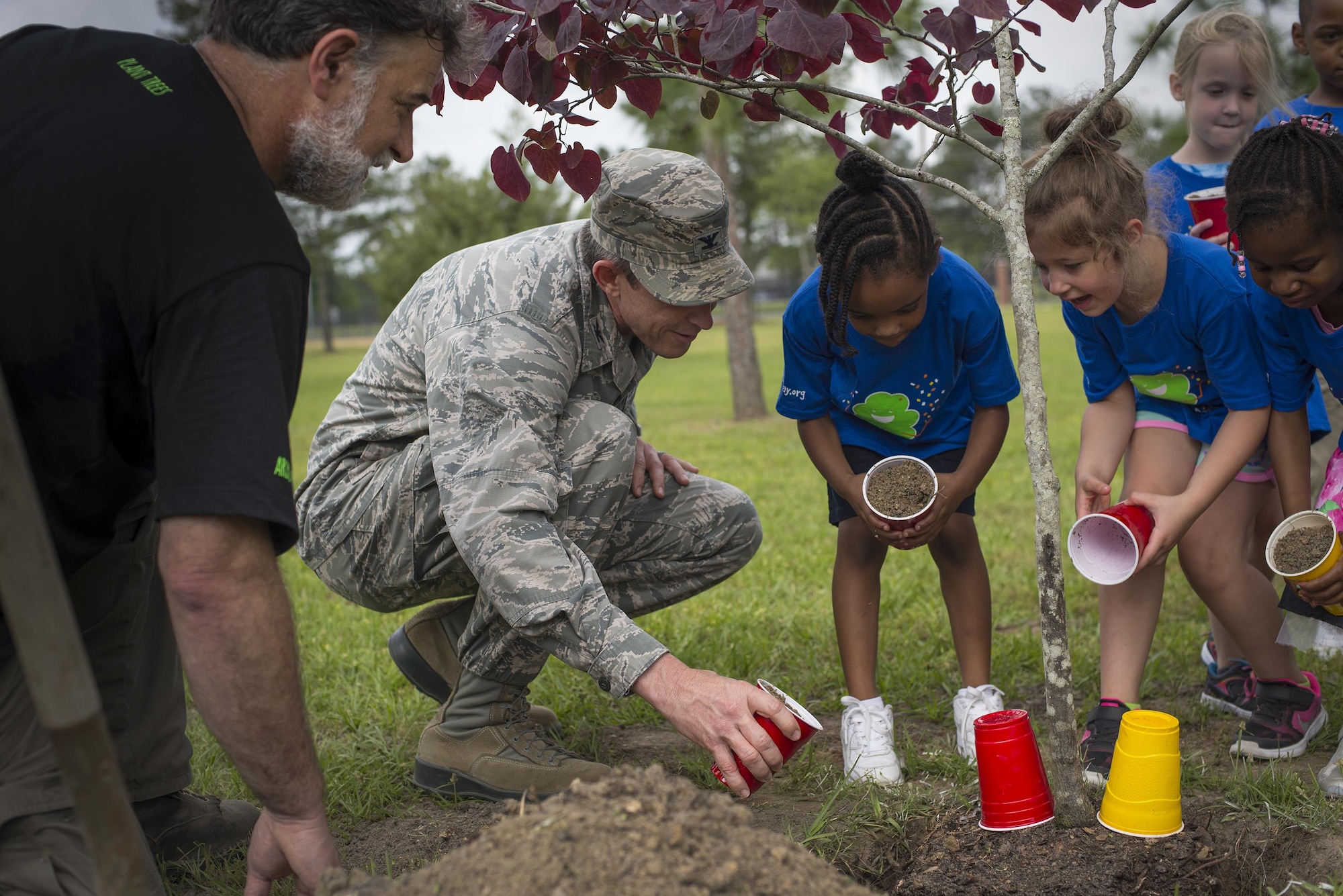 U.S. Air Force Col. Thomas Kunkel, 23d Wing commander, helps children from the Child Development Center II fill the base of a tree with dirt during an Arbor Day ceremony, April 28, 2016, at Moody Air Force Base, Ga. The base forester informed children that trees help provide clean air and clean water. (U.S. Air Force photo by Airman Daniel Snider/Released)