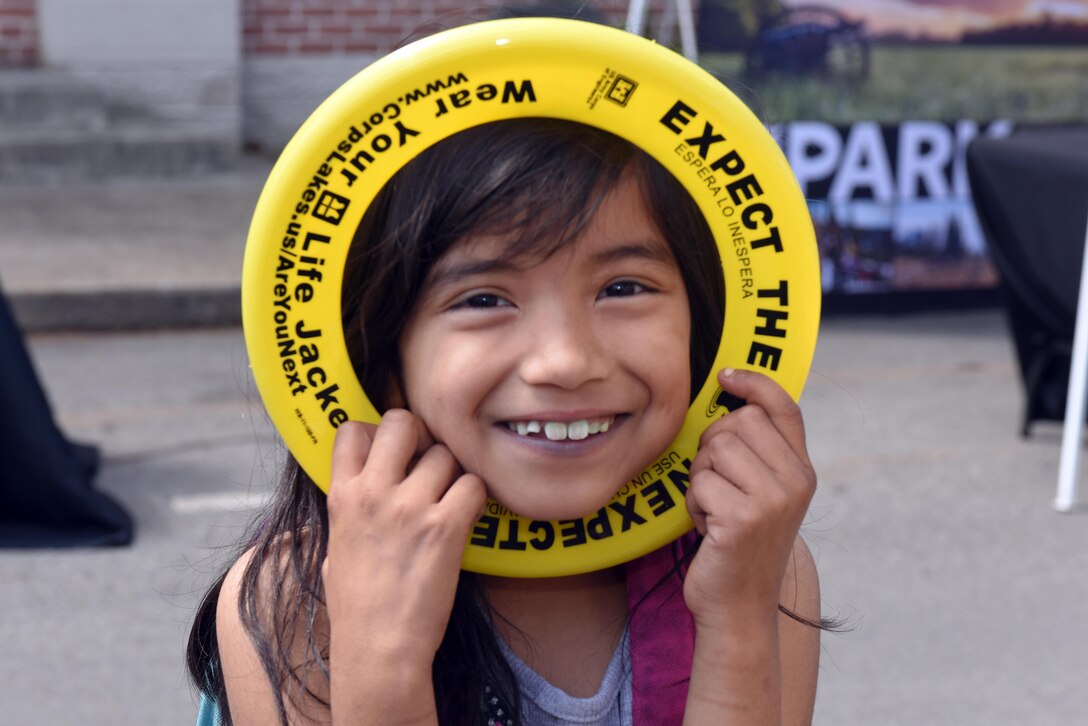 This girl poses with a water safety frisbee she received at the U.S. Army Corps of Engineers Nashville District booth during Earth Day festivities at Town Square in Murfreesboro, Tenn., April 23, 2016. 