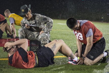 Army Reserve drill sergeant, Sgt. 1st Class Kelly Foronda, 95th Training Div. (IET), grades the sit-ups of Staff Sgt. Madison Peters, Military Intelligence Readiness Command, during the Army Physical Fitness Test at the 2016 U.S. Army Reserve Best Warrior Competition at Fort Bragg, N.C., May 3. Soldiers competing for the title of Army Reserve Best Warrior began a rainy Tuesday morning taking the Army Physical Fitness Test at Hedrick Stadium on the post. This year’s Best Warrior Competition will determine the top noncommissioned officer and junior enlisted Soldier who will represent the U.S. Army Reserve in the Department of the Army Best Warrior Competition later this year at Fort A.P. Hill, Va.  (U.S. Army photo Sgt. 1st Class Brian Hamilton/released)