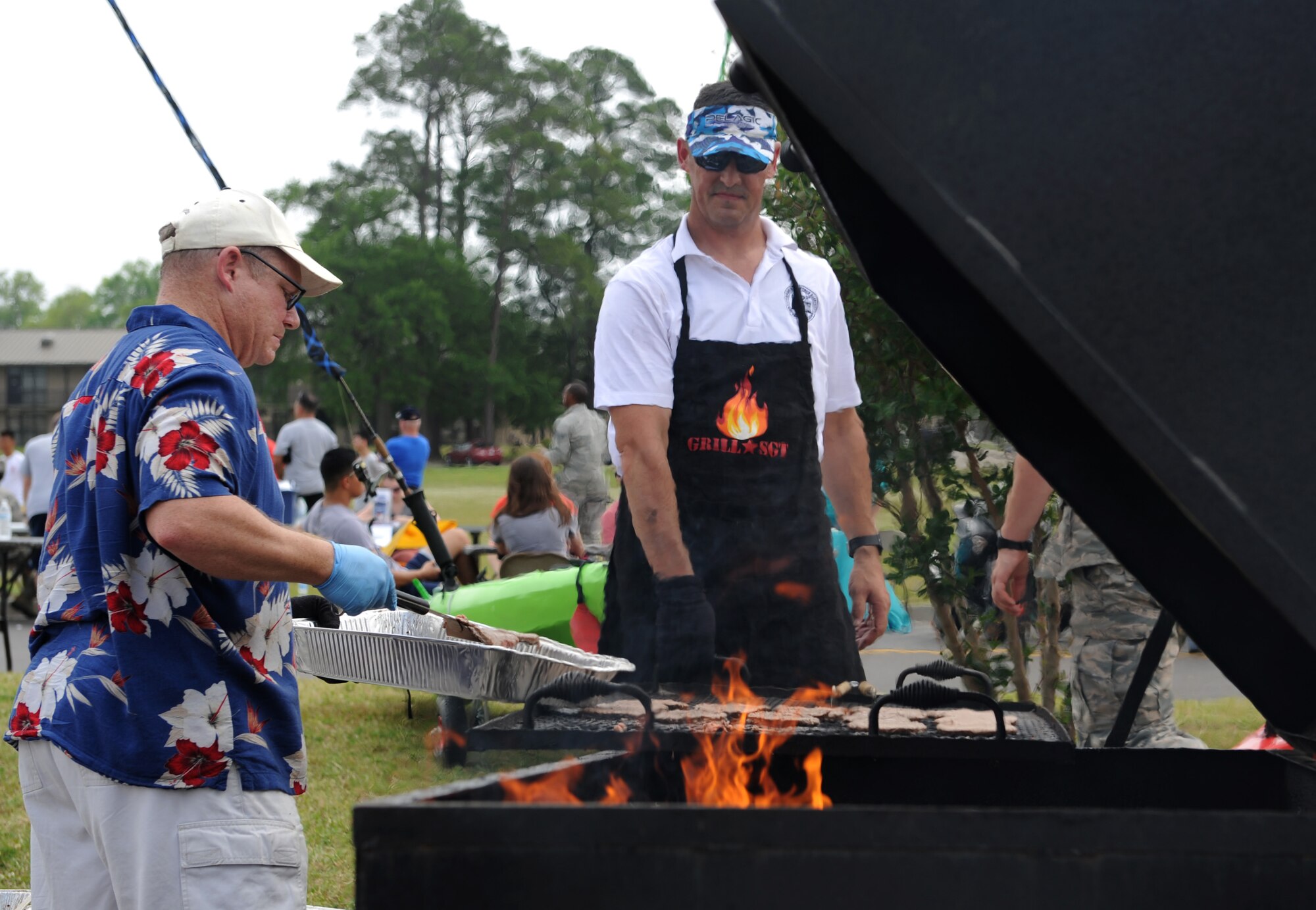 Master Sgt. David Summers, 2nd Air Force software development manager, and Master Sgt. Christopher Walton, 335th Training Squadron first sergeant, grill hamburgers during a burger burn April 29, 2016, Keesler Air Force Base, Miss. The burger burn was the final event of Wingman Week in support of Comprehensive Airman Fitness. (U.S. Air Force photo by Kemberly Groue)