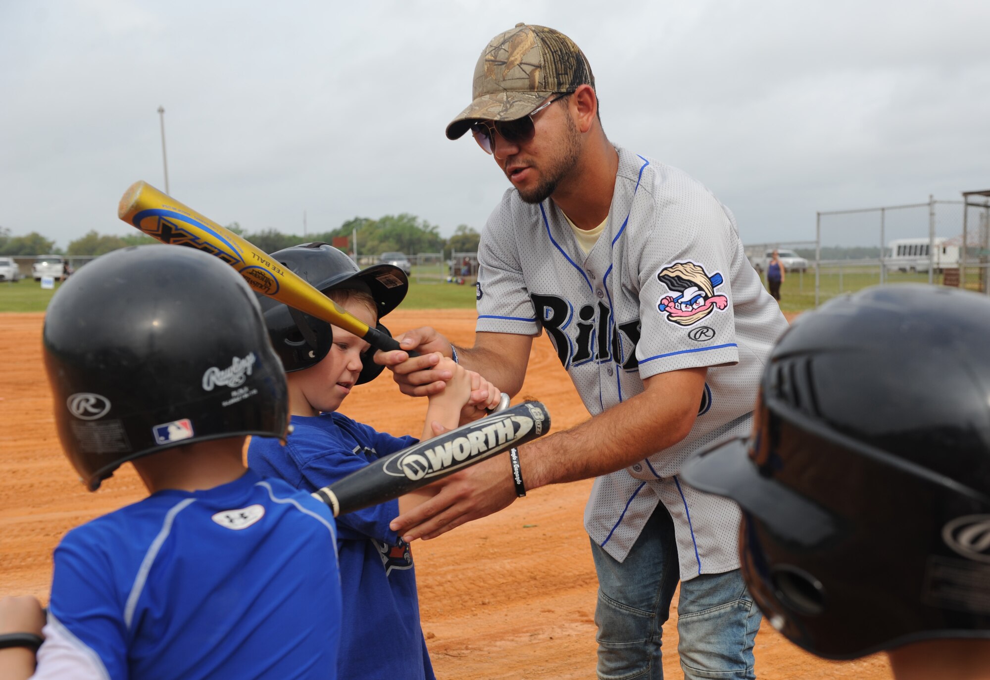 Javier Betancourt, Biloxi Shuckers second baseman, shows Keesler children how to grip a bat during the Biloxi Shucker’s Youth Baseball Clinic at the youth center baseball field April 30, 2016, Keesler Air Force Base, Miss. The clinic provided hitting, pitching, base running and fielding instruction from members of the Biloxi Shucker’s minor league baseball team. (U.S. Air Force photo by Kemberly Groue)