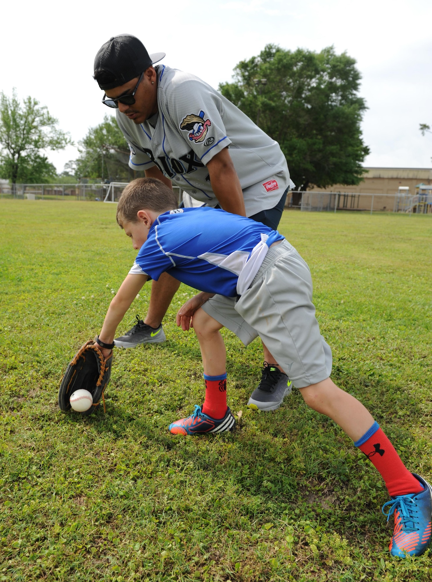 L.J. Reents, son of Master Sgt. Jamie Cleveland, 81st Surgical Operations Squadron physical therapy NCO in charge, receives fielding technique instruction from Rene Garcia, Biloxi Shuckers catcher, during the Biloxi Shucker’s Youth Baseball Clinic at the youth center baseball field April 30, 2016, Keesler Air Force Base, Miss. The clinic provided hitting, pitching, base running and fielding instruction from members of the Biloxi Shucker’s minor league baseball team. (U.S. Air Force photo by Kemberly Groue)