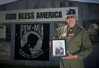 Retired Lt. Col. Bill "Shortfinger" Schwertgege, an F-4 Phantom pilot and Vietnam War POW, points to Neil S. Bynums Name on the Woodring Wall of Honor, at Woodring Regional Airport, Enid Oklahoma. The Woodring Wall was won of the two traveling Vietnam War Memorial Walls. it is a 90 percent replica of the original memorial in Washington D.C. it found a permenant home in Enid in 2013. Schwertfeger served with Bynum, who is still missing in action in Vietnam, and wears Bynum's POW/MIA bracelet. (U.S. Air Force photo/Staff Sgt. James Bolinger)