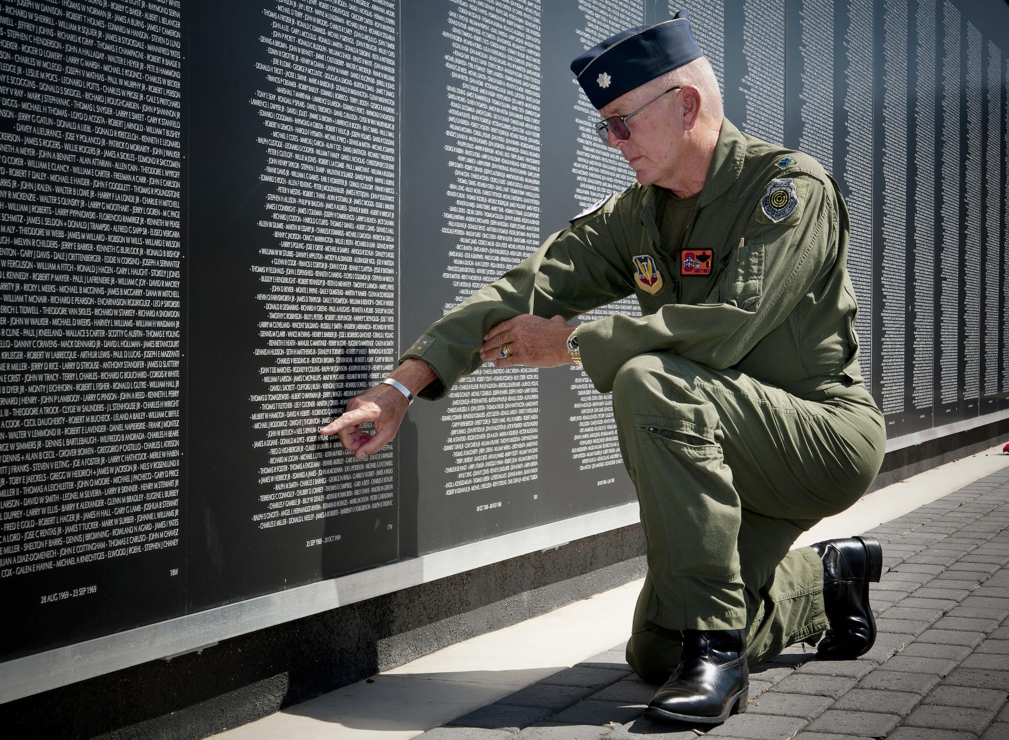 Retired Lt. Col. Bill "Shortfinger" Schwertgege, an F-4 Phantom pilot and Vietnam War POW, points to Neil S. Bynums Name on the Woodring Wall of Honor, at Woodring Regional Airport, Enid Oklahoma. The Woodring Wall was won of the two traveling Vietnam War Memorial Walls. it is a 90 percent replica of the original memorial in Washington D.C. it found a permenant home in Enid in 2013. Schwertfeger served with Bynum, who is still missing in action in Vietnam, and wears Bynum's POW/MIA bracelet. (U.S. Air Force photo/Staff Sgt. James Bolinger)