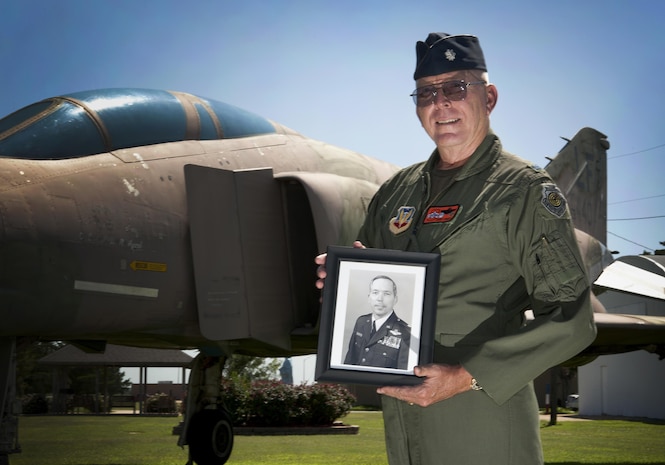 Retired Lt. Col. Bill "Shortfinger" Schwertgege, an F-4 Phantom pilot and Vietnam War POW, points to Neil S. Bynums Name on the Woodring Wall of Honor, at Woodring Regional Airport, Enid Oklahoma. The Woodring Wall was won of the two traveling Vietnam War Memorial Walls. it is a 90 percent replica of the original memorial in Washington D.C. it found a permenant home in Enid in 2013. Schwertfeger served with Bynum, who is still missing in action in Vietnam, and wears Bynum's POW/MIA bracelet. (U.S. Air Force photo/Staff Sgt. James Bolinger)