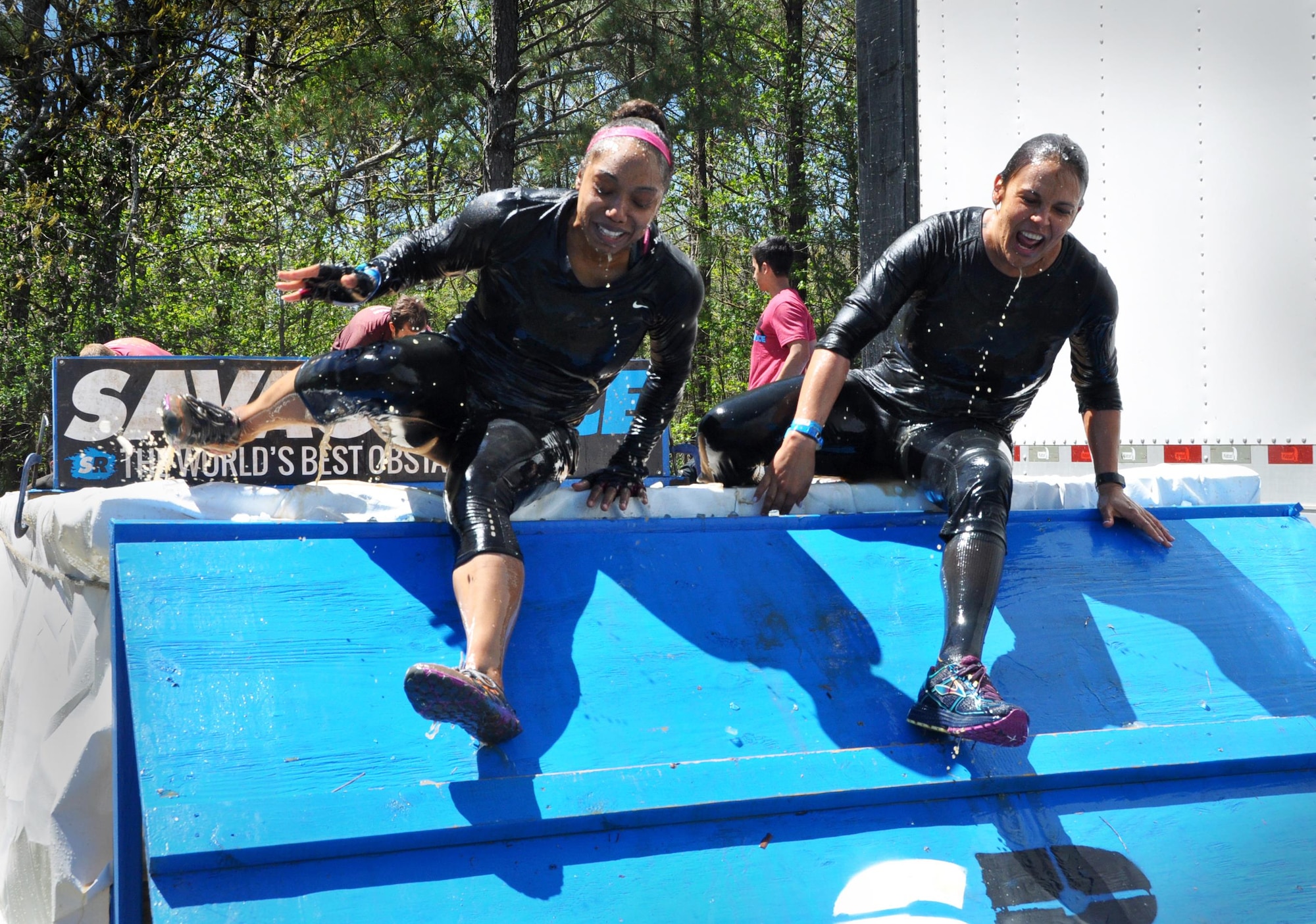 Major Stephanie Hahn, 94th Airlift Wing executive officer, and Capt. Natalie Campos, 22nd Air Force executive officer, appear almost choreographed as they emerge simultaneously from the ice pool during the Savage Race on April 9, 2016 in Dallas, Georgia. These members of Team Dobbins moved swiftly through every obstacle with cheerful faces throughout.  (U.S. Air Force photo by Senior Airman Lauren Douglas)