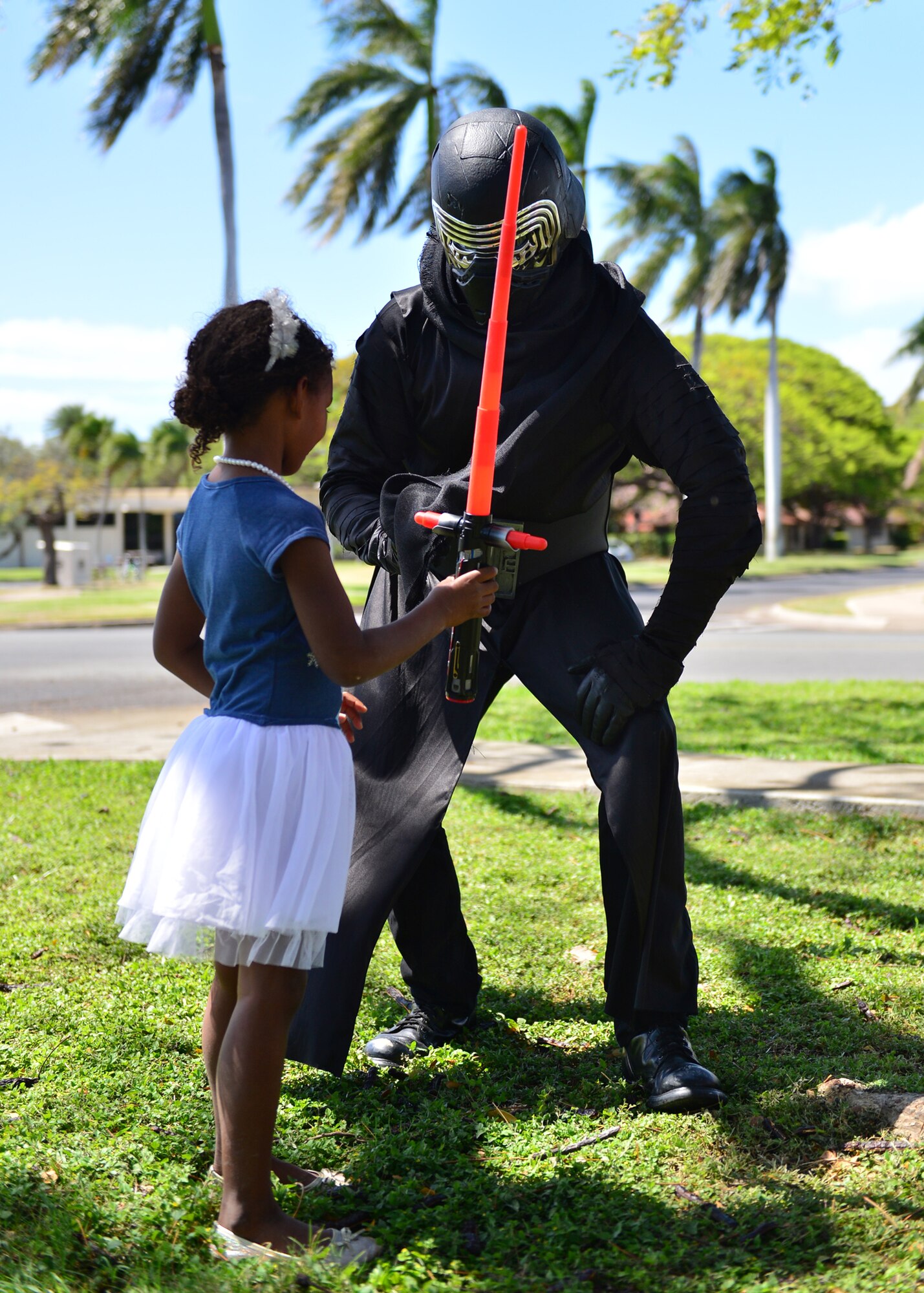 Senior Airman Michael Reeves, 15th Wing Public Affairs, dressed as Kylo Ren, shows off a lightsaber during the Books on Bases event on Joint Base Pearl Harbor-Hickam, April 28, 2016. In celebration of the Month of the Military Child, the 15th Wing Public Affairs office and JBPHH Public Affairs office teamed up with Blue Star Families to provide more than 1,000 books to children of servicemembers. The free event, which also offered attendees an opportunity to take pictures with a few of their favorite super heroes, also doubled as a food drive. More than 300 pounds of canned good items were collected to donate to local food banks. (U.S. Air Force Photo by Tech. Sgt. Aaron Oelrich/Released)