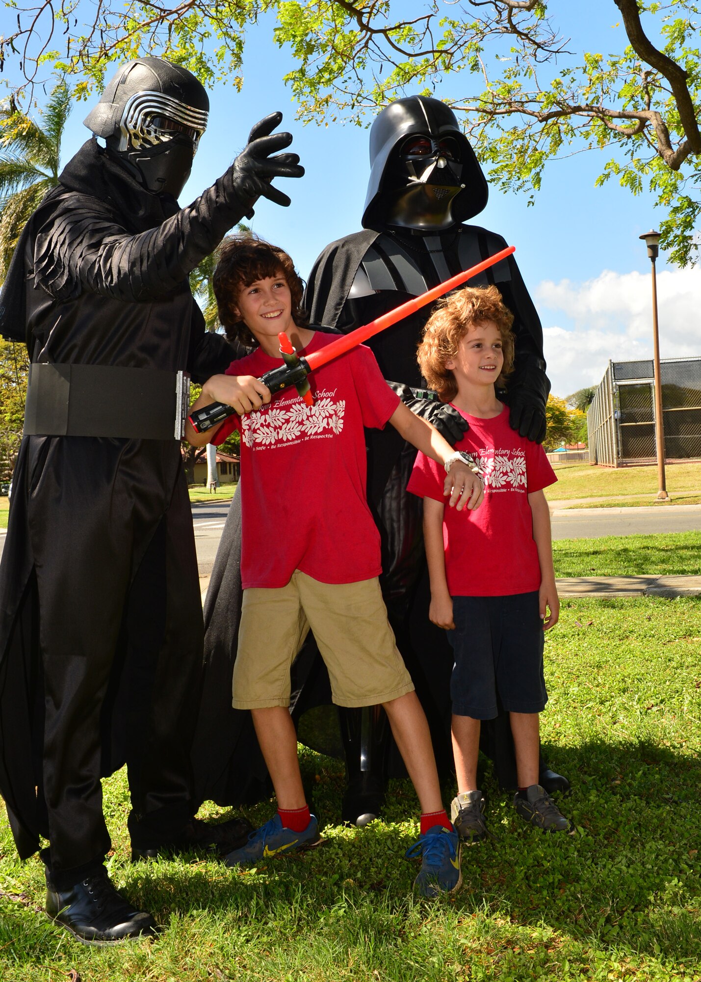 Senior Airman Michael Reeves, 15th Wing Public Affairs, dressed as Kylo Ren and Lt. Col. Christopher Lapack, 15th Wing Chaplin, dressed as Darth Vader, poses for a phot with Troy and Landon Trazoon during the Books on Bases event on Joint Base Pearl Harbor-Hickam, April 28, 2016. In celebration of the Month of the Military Child, the 15th Wing Public Affairs office and JBPHH Public Affairs office teamed up with Blue Star Families to provide more than 1,000 books to children of servicemembers. The free event, which also offered attendees an opportunity to take pictures with a few of their favorite super heroes, also doubled as a food drive. More than 300 pounds of canned good items were collected to donate to local food banks. (U.S. Air Force Photo by Tech. Sgt. Aaron Oelrich/Released)