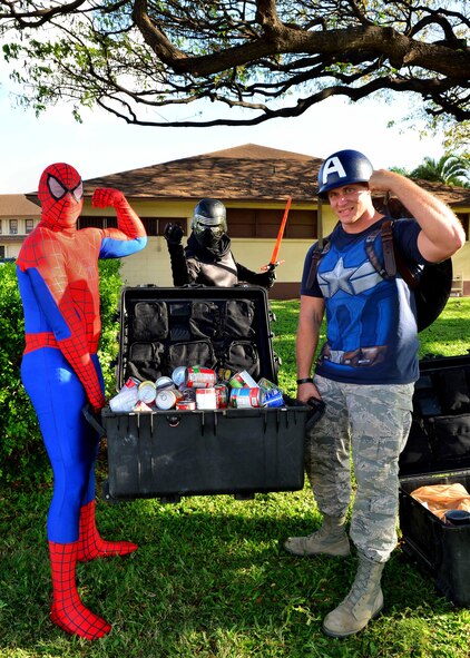 Senior Airman Michael Reeves, 15th Wing Public Affairs, dressed as Kylo Ren, SSgt. Christopher Stoltz, Joint Base Pearl Harbor-Hickam Public Affairs, dressed as Spiderman, and Tech. Sgt. Brandon Hockenbarger, 15th Medical Group, dressed as captain America, hold up the canned food donated by participants of the Books on Bases event on JBPHH, April 28, 2016. In celebration of the Month of the Military Child, the 15th Wing Public Affairs office and JBPHH Public Affairs office teamed up with Blue Star Families to provide more than 1,000 books to children of servicemembers. The free event, which also offered attendees an opportunity to take pictures with a few of their favorite super heroes, also doubled as a food drive. More than 300 pounds of canned good items were collected to donate to local food banks. (U.S. Air Force Photo by Tech. Sgt. Aaron Oelrich/Released)