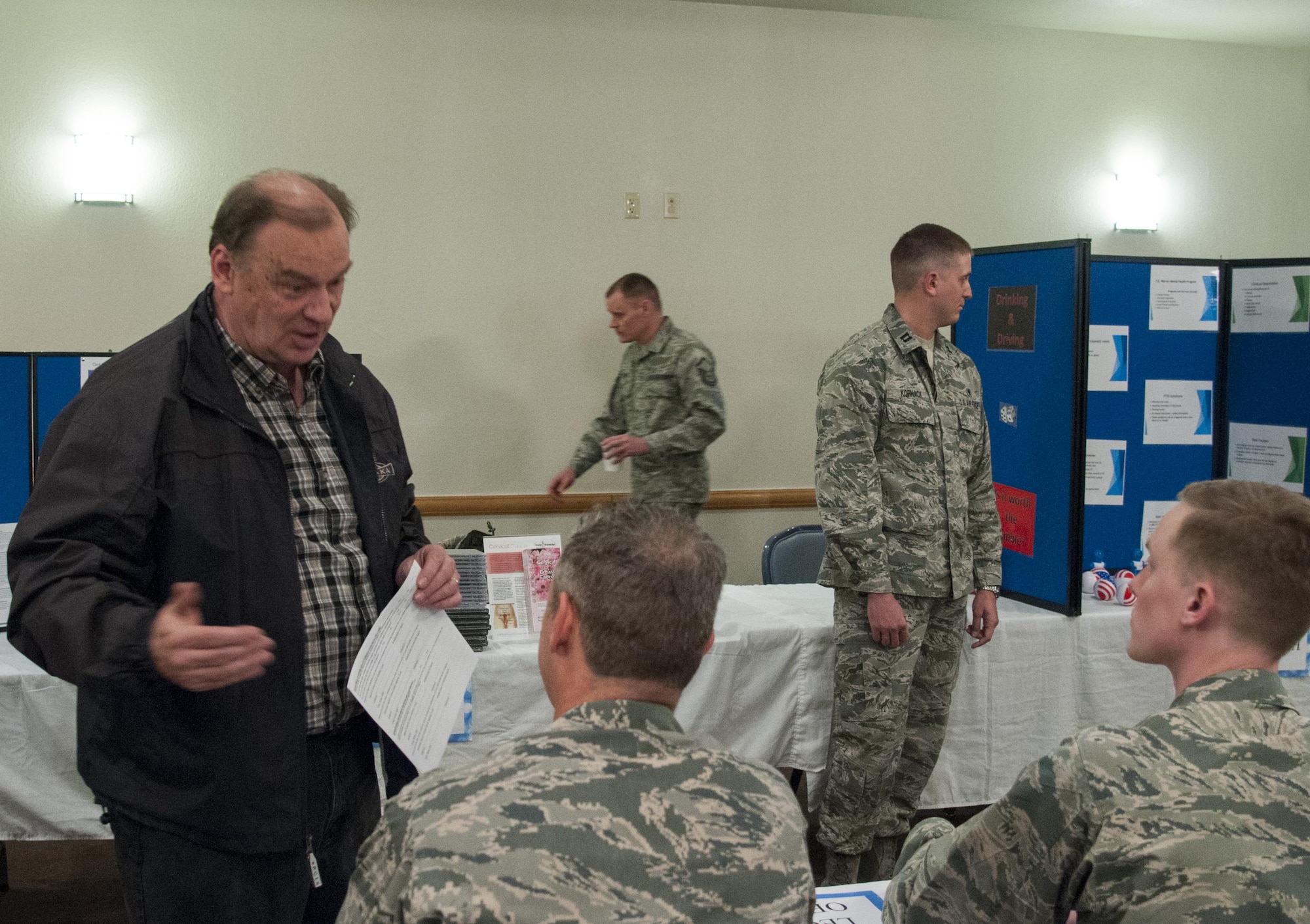Retired Staff Sgt. Brian Walker talks with 90th Missile Wing judge advocates manning an information booth during Retiree Appreciation Day on F.E. Warren Air Force Base, Wyo., April 30, 2016. The base legal office gave a briefing on their services to the more than 150 retirees and dependents who attended the event and then met with individuals to answer their questions. (U.S. Air Force photo by Senior Airman Jason Wiese)