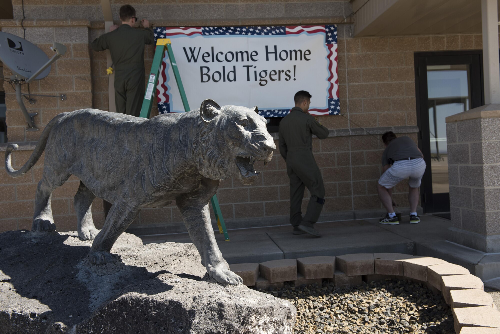 Members of the 391st Fighter Squadron hang a “Welcome Home” sign behind a statue of the squadron mascot at Mountain Home Air Force Base, Idaho, April 17, 2016. Airmen deployed to Southwest Asia in support of Operation Inherent Resolve. (U.S. Air Force photo by Airman Alaysia Berry/Released)