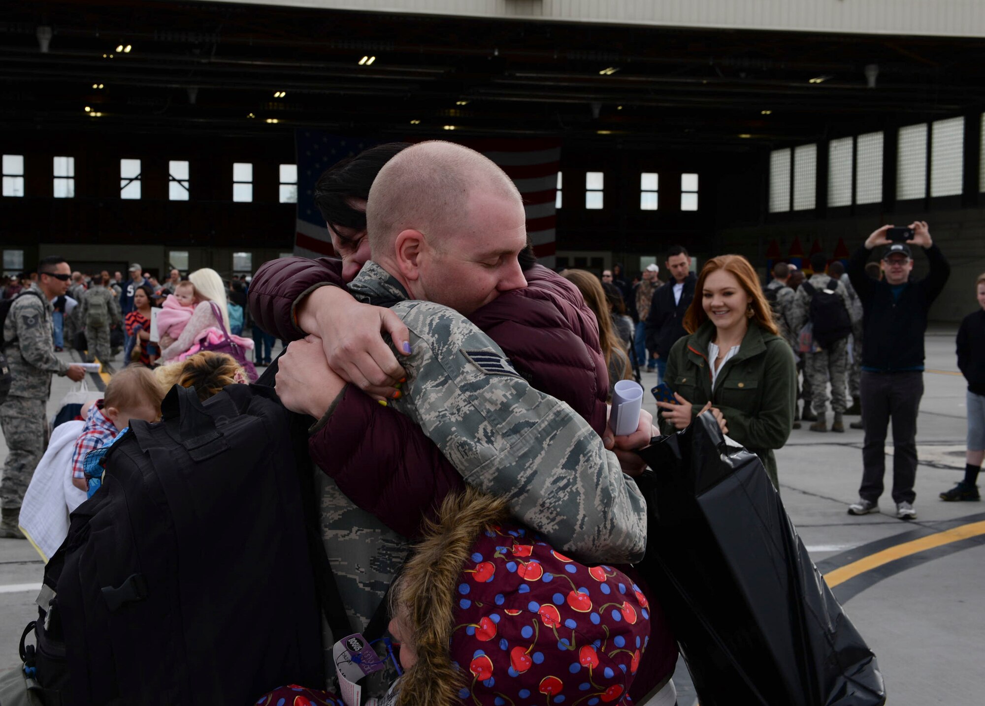A family embraces for the first time following a deployment April 24, 2016, at Mountain Home Air Force Base, Idaho. Airmen returned after serving six months in Southwest Asia. (U.S. Air Force photo by Airman 1st Class Chester Mientkiewicz/Released)