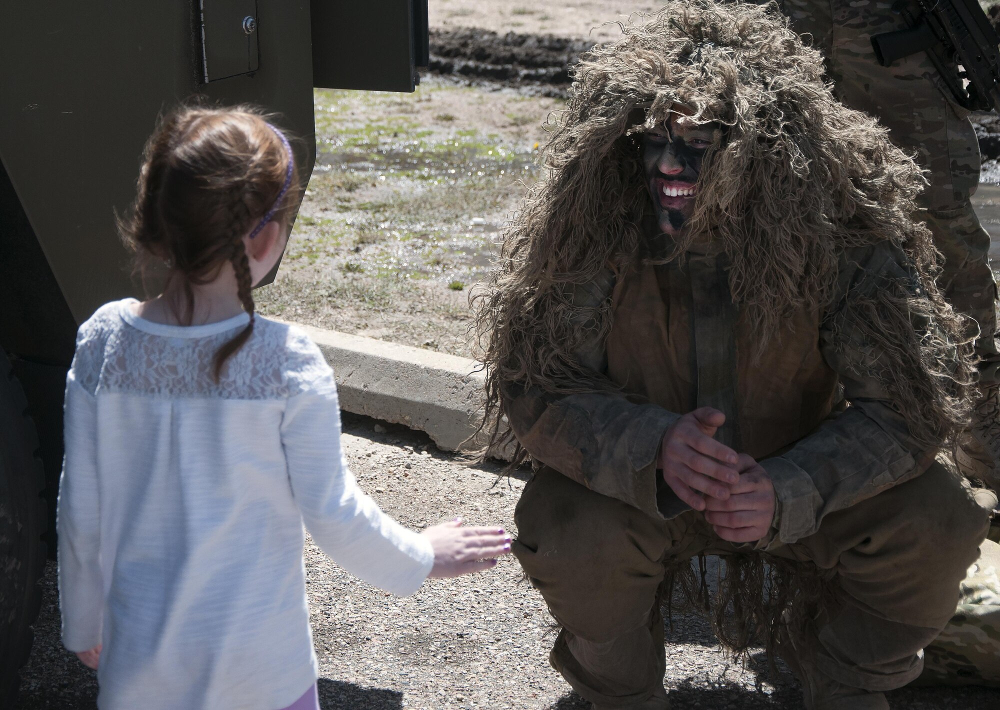 Amn. Mathew Curtis, 790th Missile Security Forces Squadron Security Support Team, speaks with Blaire Lycan, daughter of Capt. David Lycan, 90th Security Support Squadron, May 2, 2016, during a 90th Security Forces Group spouse’s appreciation week event at the Military Working Dogs facility. (U.S. Air Force photo by Senior Airman Brandon Valle)