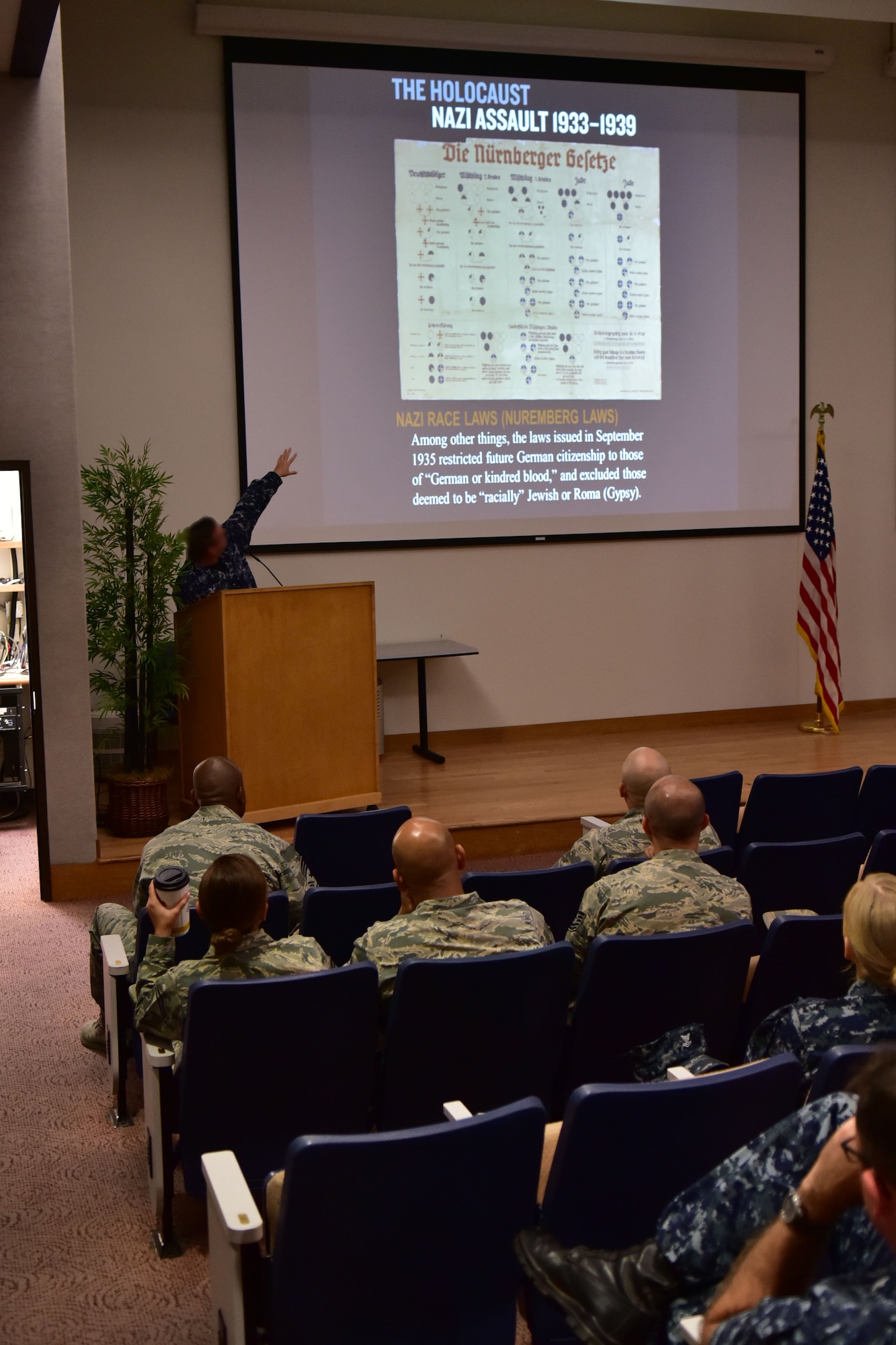 John Allen describes the details of the Nuremberg Laws during Holocaust historical and educational brief May 2, held at Hickam's Hollister Auditorium. This year's theme is 'Learning from the Holocaust, Acts of Courage,' which highlights the courageous actions of various Jewish individuals during the pre, during and post-World War II era. The brief provided in-depth insight to various atrocities the Jewish people encountered in the face of Germany's Third Reich. (U.S. Air Force photo by Staff Sgt. Christopher Stoltz)