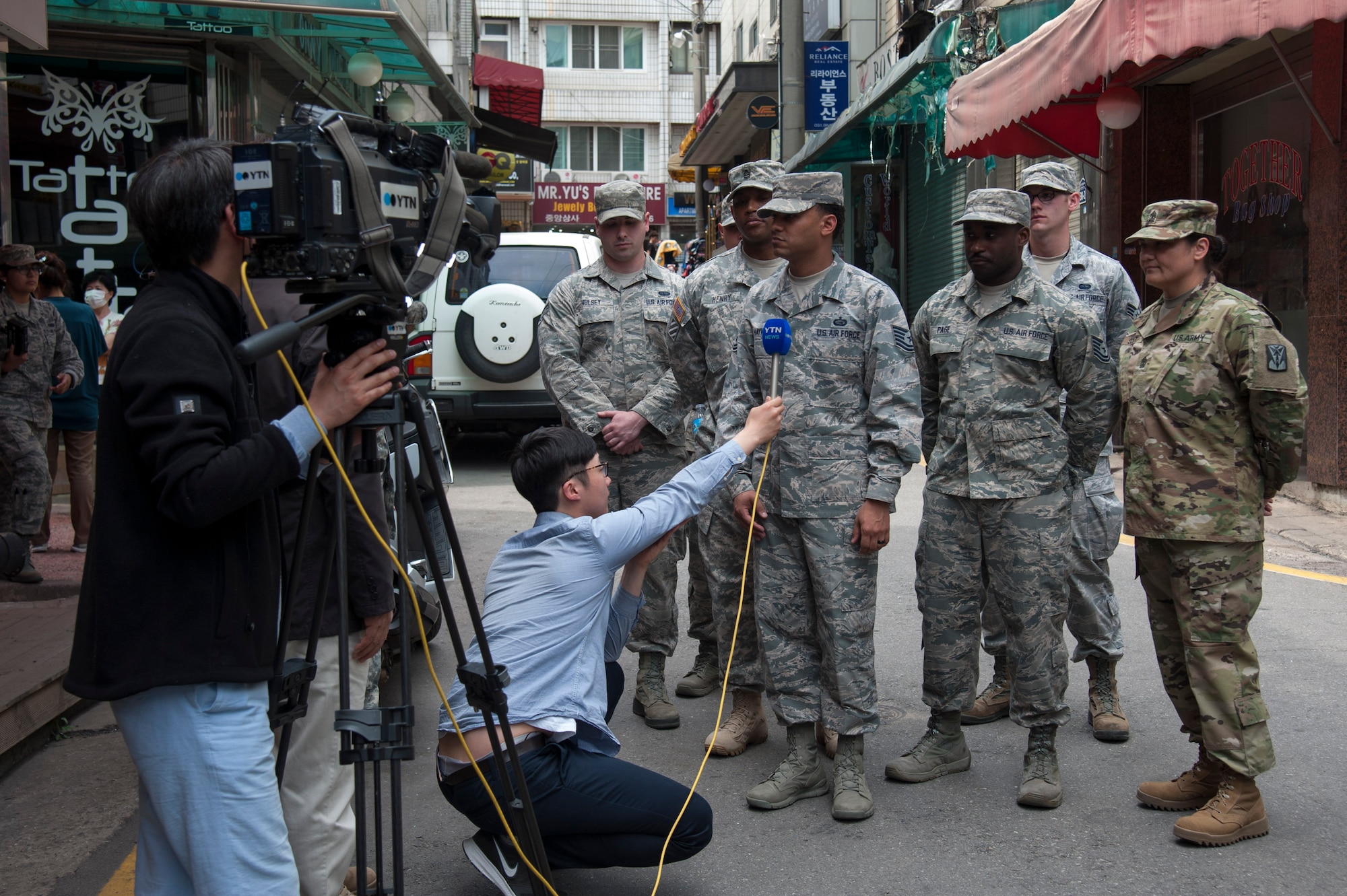 Local media interviews Team Osan members that rescued people from a fire at Songtan shopping district, Republic of Korea, May 2, 2016. The Airmen and Soldiers, along with many onlookers worked together to save the lives of an Airmen, mother and her three children when a fire broke out on April 29, 2016. (U.S. Air Force photo by Staff Sgt. Jonathan Steffen/ Released)