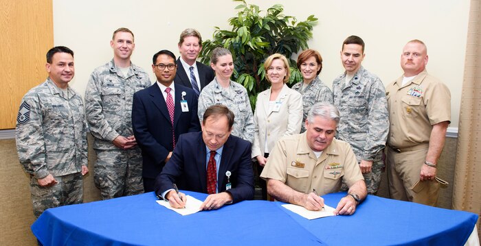 Todd Gallati, Trident Medical Center CEO, and Navy Capt. Tim Sparks, Joint Base Charleston deputy commander, sign a memorandum of agreement April 21, 2016, at the Redbank Club on Joint Base Charleston – Weapons Station, S.C. This partnership program joins military and civilian leaders to brainstorm ideas for leveraging resources. (U.S. Air Force photo/Senior Airman Clayton Cupit)
