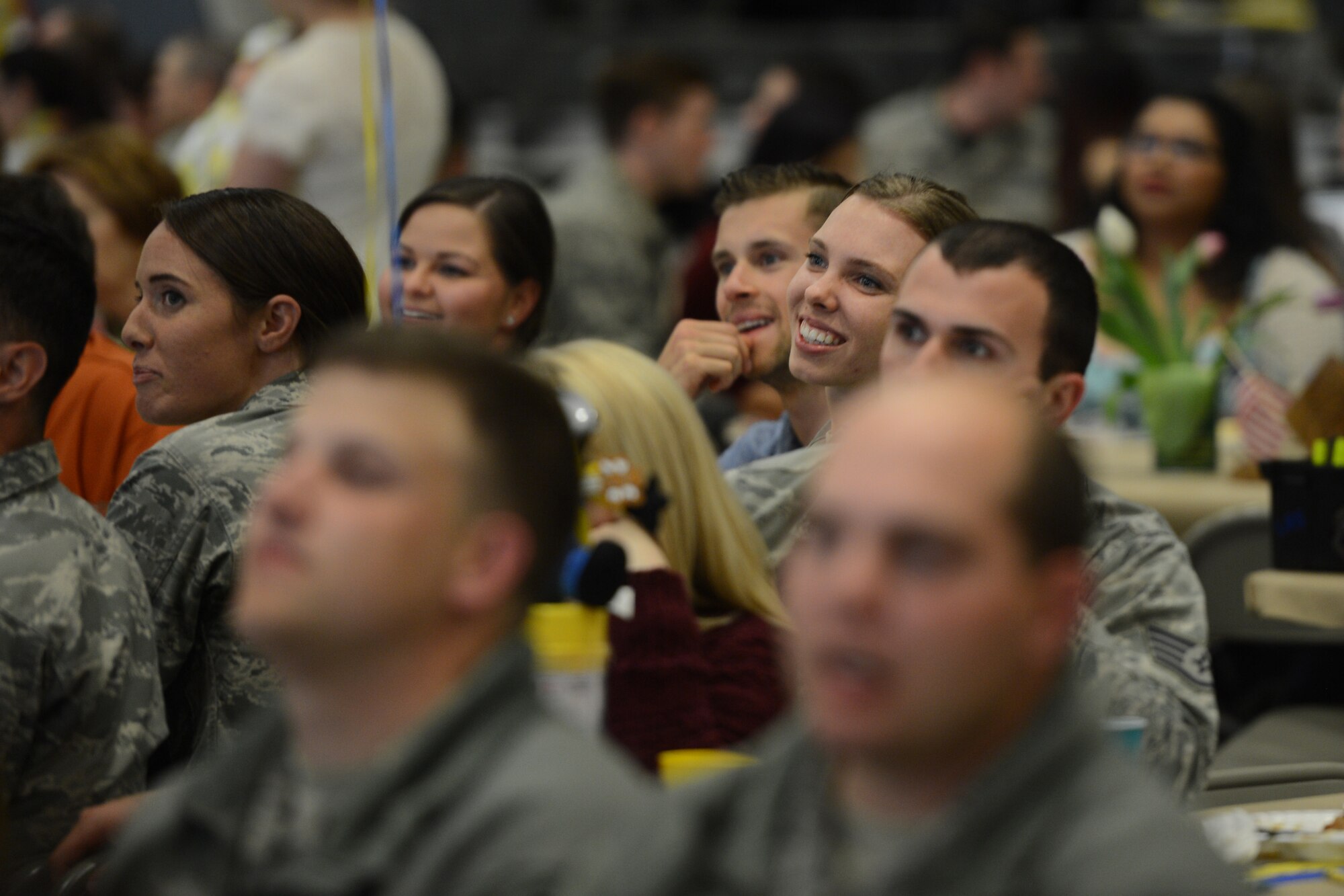 Airmen attending the 2016 Log Fest Awards dinner laugh at a squadron video, April 29, 2016, at Joint Base Lewis-McChord, Wash. There was a total of 72 Knucklebuster award nominees for this year’s event at McChord Field. (U.S. Air Force photo/Senior Airman Jacob Jimenez) 
