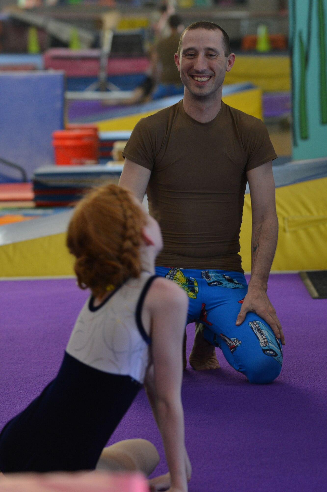 U.S. Army Staff Sgt. Zachary Bass, a small group leader with the Fort Eustis Army Aviation Center of Excellence Noncommissioned Officer Academy, takes a break with his step-daughter, Ally Aspen, during an aerial acrobats practice in Hampton, Va., April 26, 2016. Shortly after Ally started the sport, both of her parents became involved by practicing various forms of acrobatics with her. (U.S. Air Force photo by Staff Sgt. Natasha Stannard)