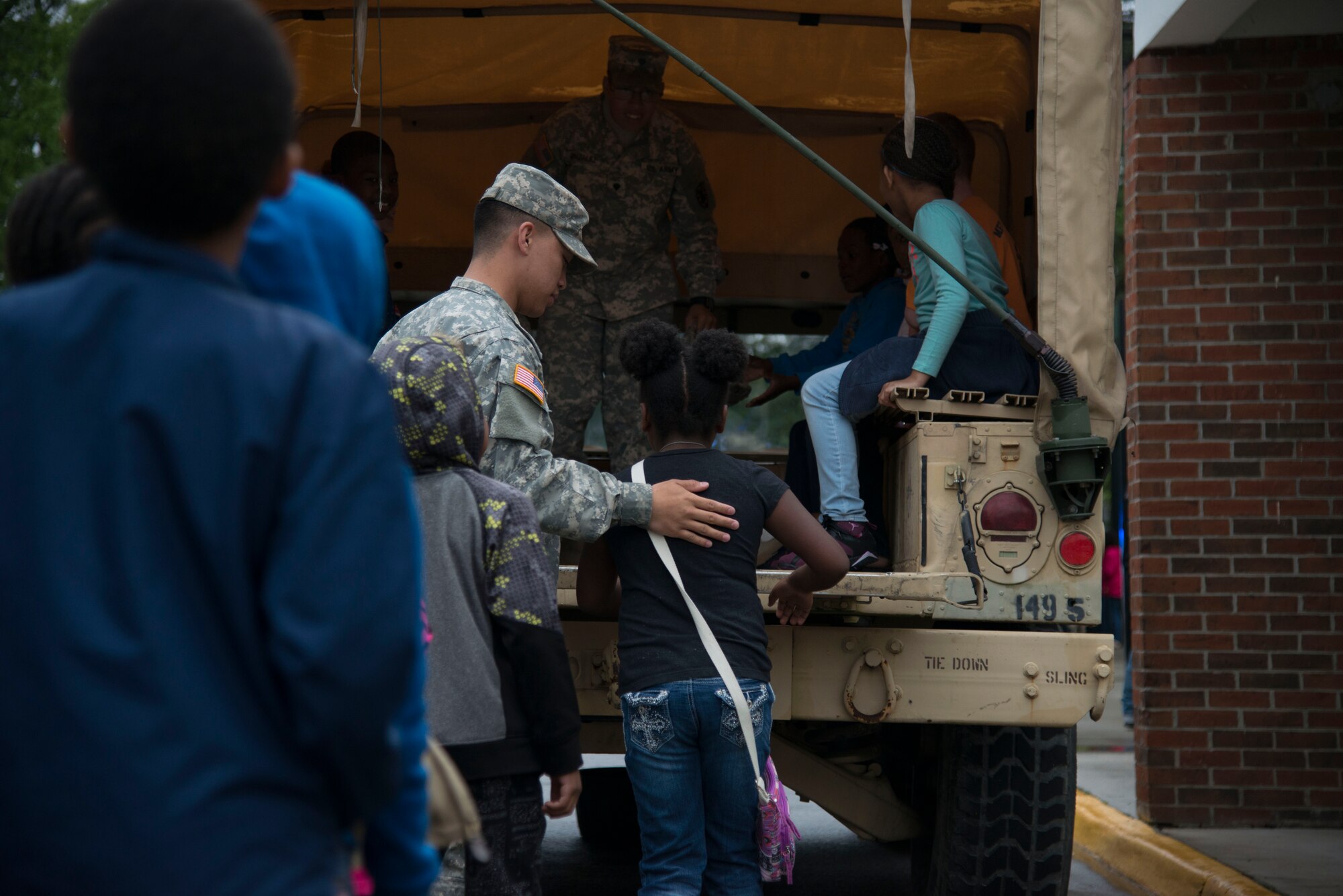 U.S. Army Soldiers from Fort Eustis, Va., help Richneck Elementary students into the back of a HMMVW during a career day in Newport News, Va., April 29, 2016. The Soldiers visited to strengthen community partnerships with the local school, its students and faculty. (U.S. Air Force photo by Senior Airman Kristina LaCoste)
