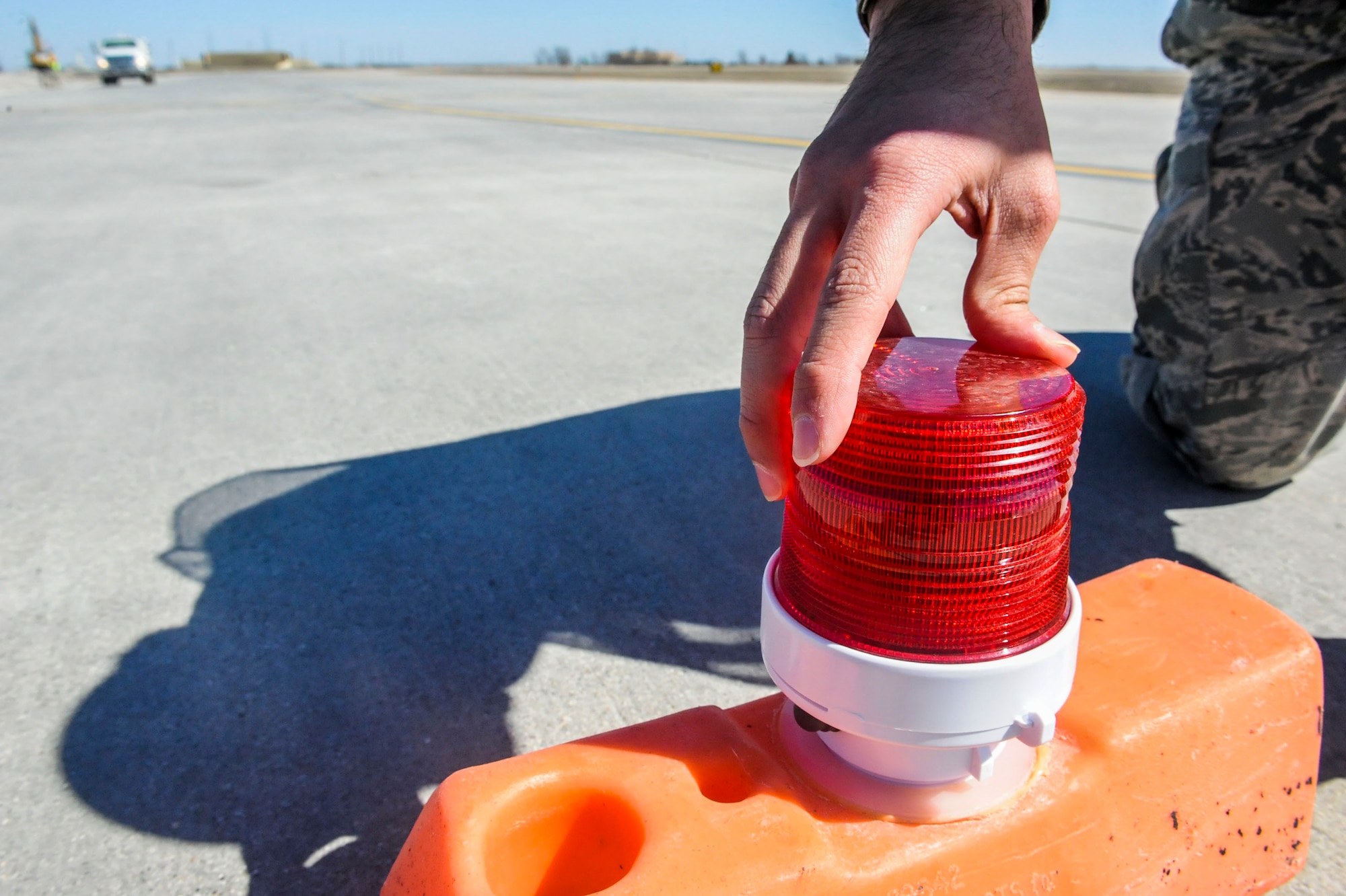 An airfield management Airmen assigned to the 5th Operations Support Squadron inspects a light on a barricade located on taxiway delta and delta hammerhead at Minot Air Force Base, N.D., April 13, 2016. Barricades are positioned to define the limits of hazardous areas, and lights are checked daily to ensure they are positioned and working properly. (U.S. Air Force photo/Airman 1st Class Jessica Weissman)