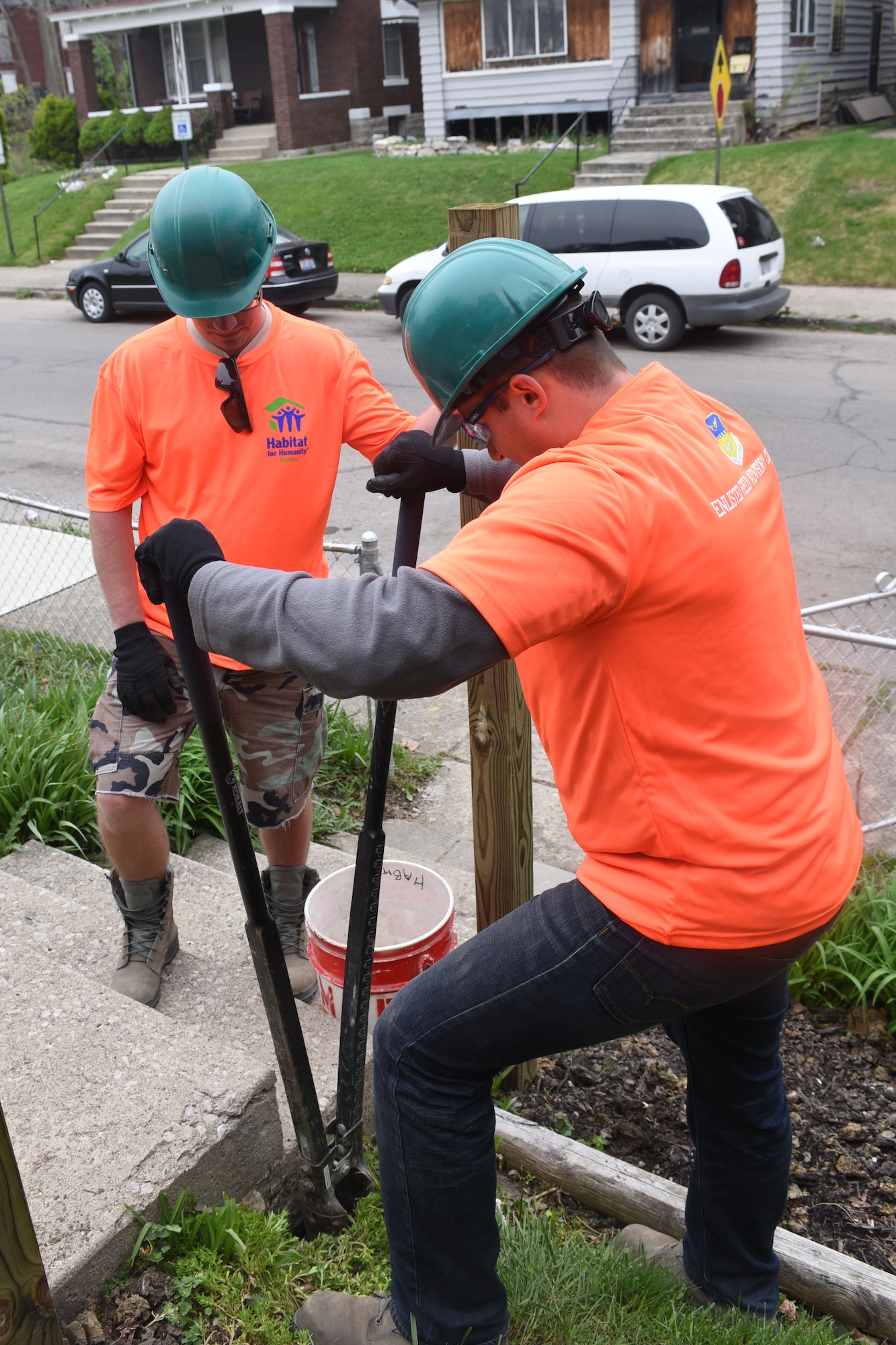 U.S. Air Force Senior Airman Brayden Pratt, with the 121st Logistics Readiness Squadron, digs a hole to put in a railing support post during a community outreach program with Habitat for Humanity April 23, 2016 Columbus, Ohio. EFAC Airmen helped to build a new walkway railing, repaint window sills and replace old windows for a local family in need. (U.S. Air National Guard photo by Airman 1st Class Ashley Williams/Released)