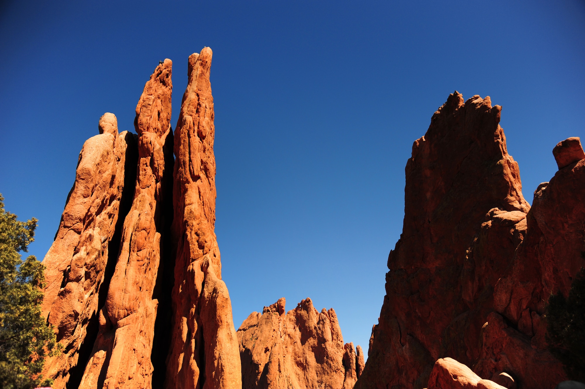COLORADO SPRINGS, COLO.  – The Three Graces, a triple spire sandstone formation, glows red-orange in the noonday sun at the Garden of the Gods, April 7, 2016. The Three Graces is just one of the many famous rock formations visible as you travel the 15 miles of trails throughout the park.  (U.S. Air Force photo/Staff Sgt. Amber Grimm)