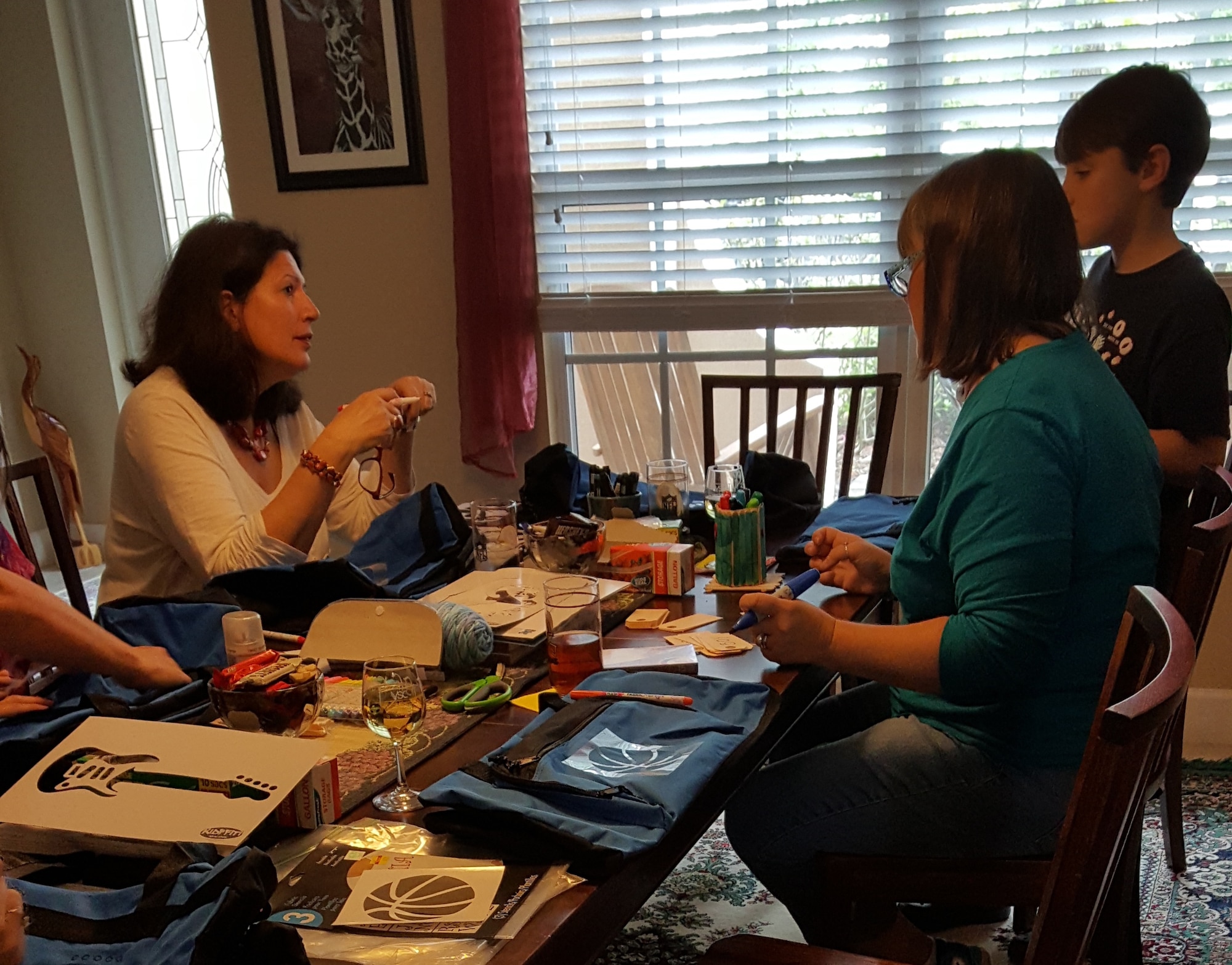 Gina Monteith and Ainsley Gottrich, key spouses for Patrick Air Force Base and Cape Canaveral Air Force Station, decorate ‘Sweet Cases’ to aid local foster children in transitioning to a new home April 16, 2016, at Patrick AFB. The project, which took place over several weeks, consisted of creating 48 bags filled with items such as teddy bears, coloring books and crayons, toothbrush kits, fleece blankets, puzzles and playing cards. (Courtesy photo)