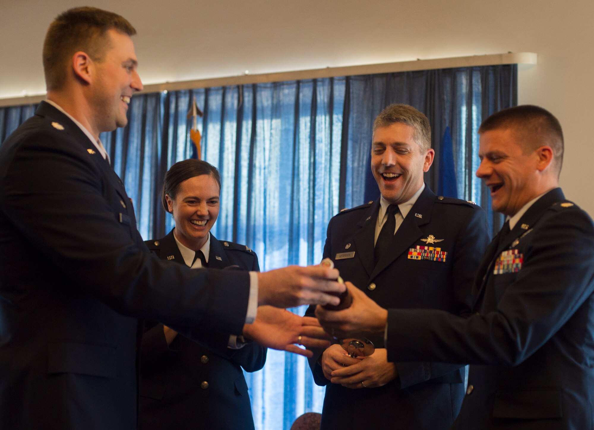 Lt. Col. Michael Medgyessy, 691st Cyberspace Operations Squadron commander, presents gifts to celebrate the activation of the new unit April 21, 2016, at Ramstein Air Base, Germany. Due to the cyberspace environment constantly evolving, the 691st COS team has the intent to strengthen the new unit by maturing its capabilities and grow the Cyber Security and Control weapon system and the operational capabilities of the unit. (U.S. Air Force photo/Senior Airman Jonathan Stefanko)