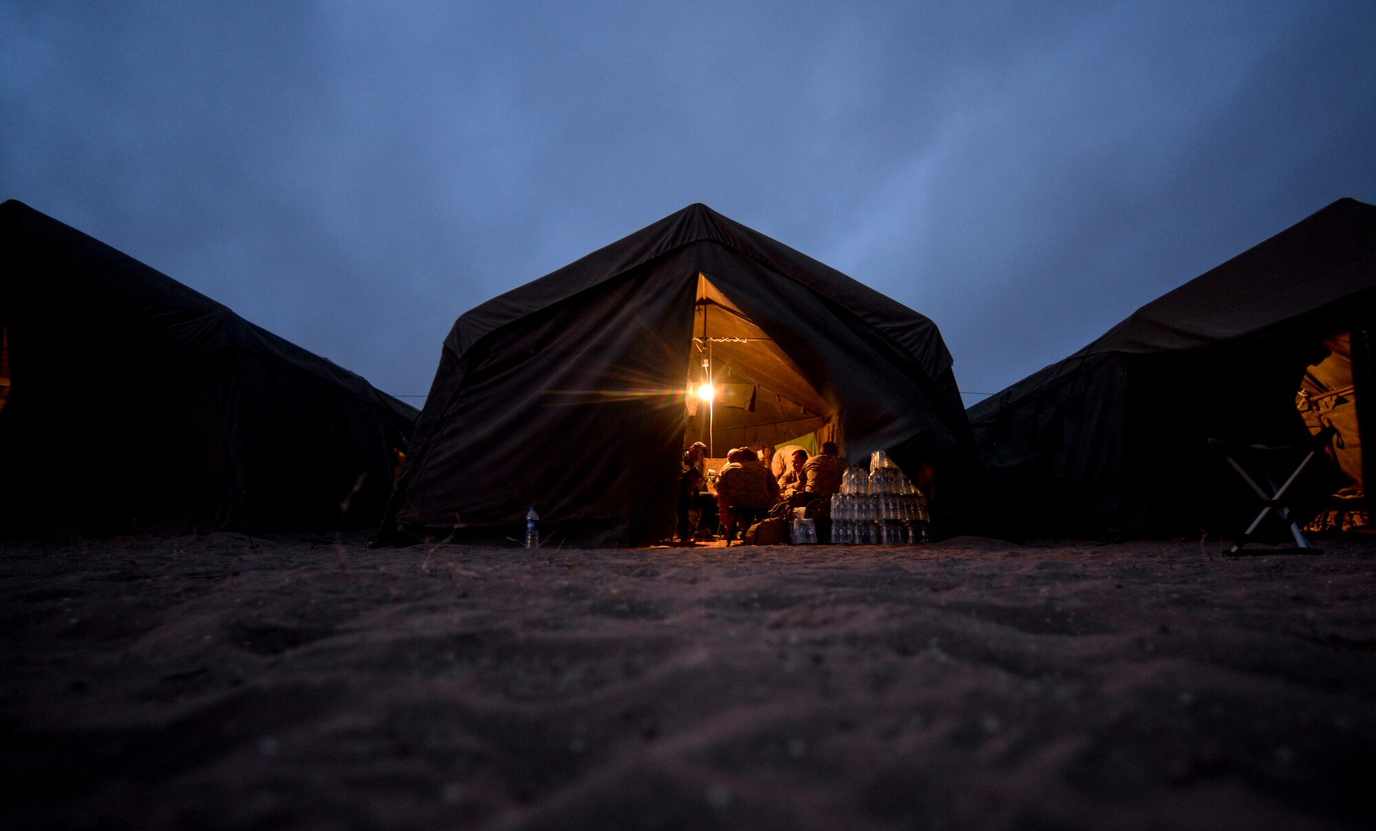 Military members participating in AFRICAN LION 16 gather inside of their tents at the end of the day at Tifnit, Kingdom of Morocco, April 23, 2016. Of the 11 nations participating in the annual exercise, a group of U.S. military members, Royal Moroccan armed forces members, Spanish Legion soldiers and Royal Netherlands army soldiers lived in field conditions and participated in daily familiarization with other nations’ tactics to improve interoperability. (U.S. Air Force photo by Senior Airman Krystal Ardrey/Released)