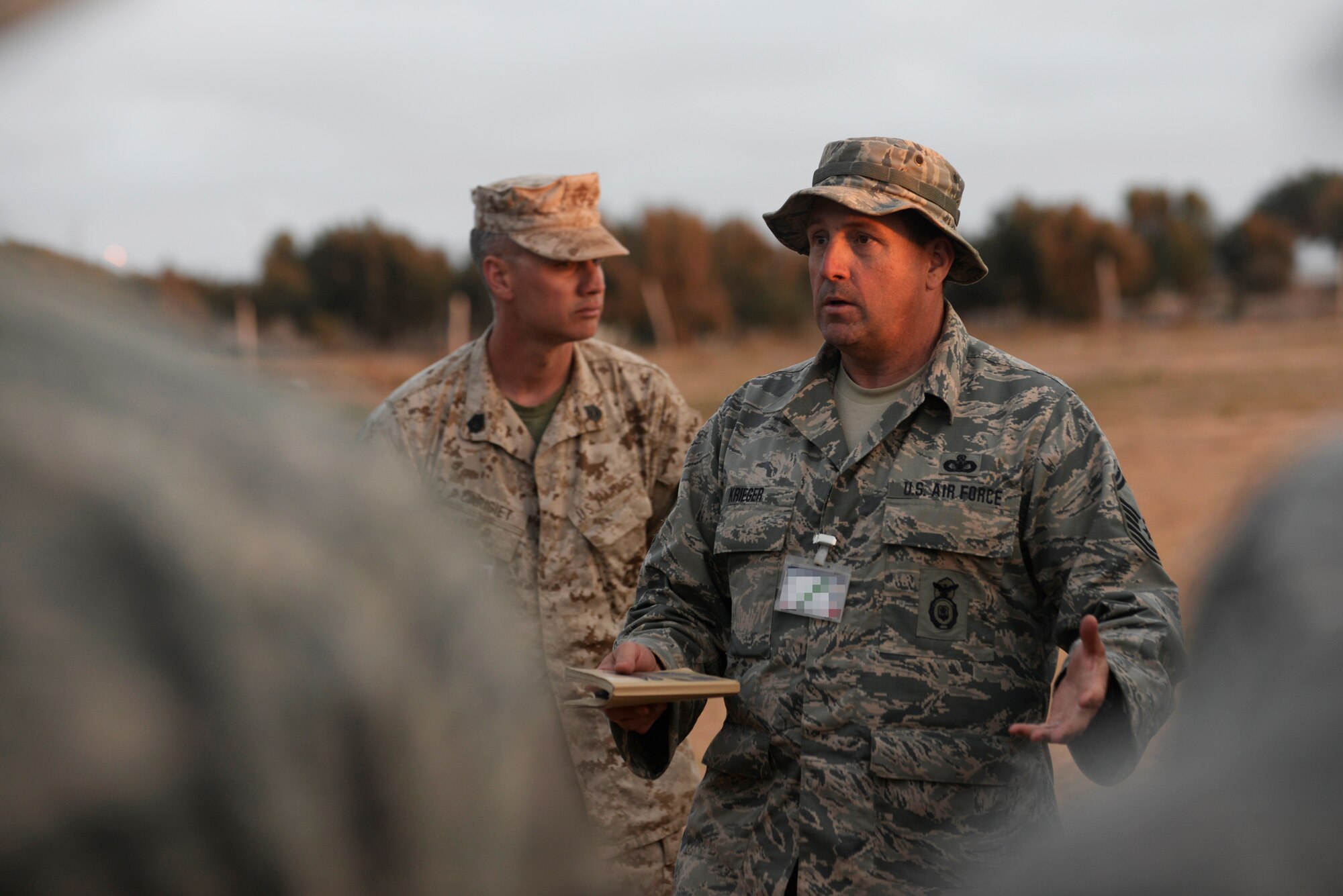 U.S. Air Force Senior MSgt. Klint Krieger, 403rd Security Forces Squadron exercise company first sergeant, speaks to military members from four different countries at an end-of-day brief during AFRICAN LION 16 at Tifnit, Kingdom of Morocco, April 23, 2016. Krieger is an Air Force Reservist and the majority of the Air Force contingent, are Air Force Reservists or Air Guardsmen. The annual exercise brought together 11 different countries to participate in a Combined Joint Task Force command post exercise and a peace support operations field training to improved interoperability between countries. (U.S. Air Force photo by Senior Airman Krystal Ardrey/Released)